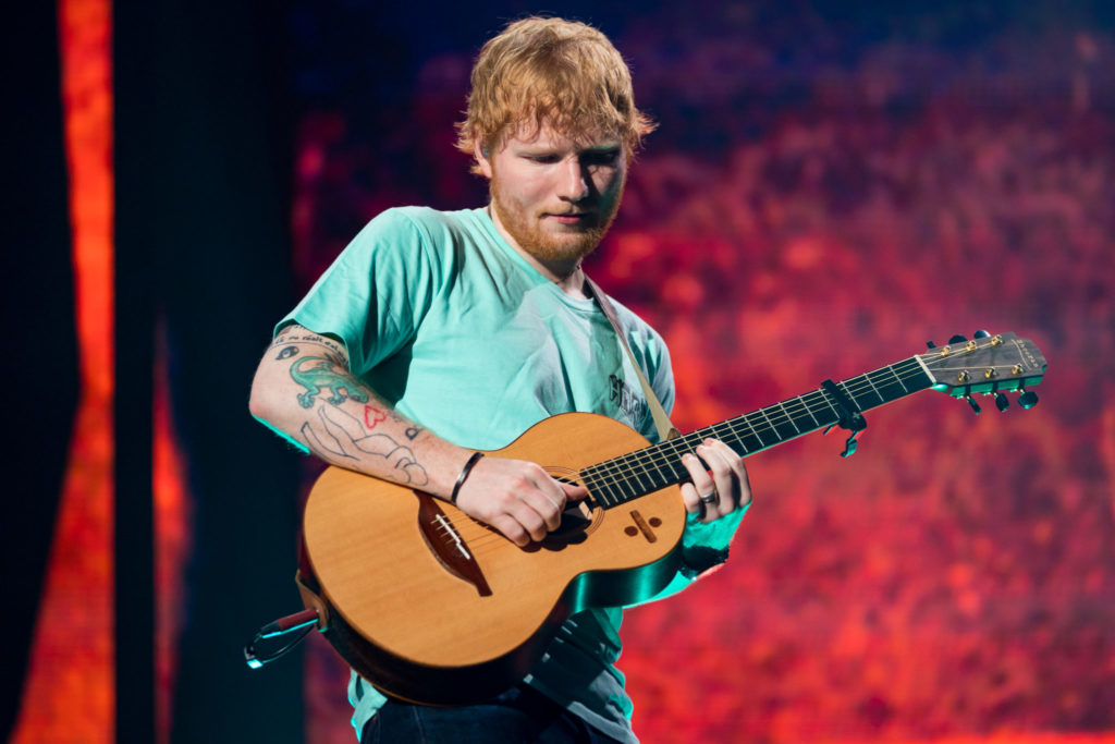 Ed Sheeran strums away on his guitar and loop pedal
