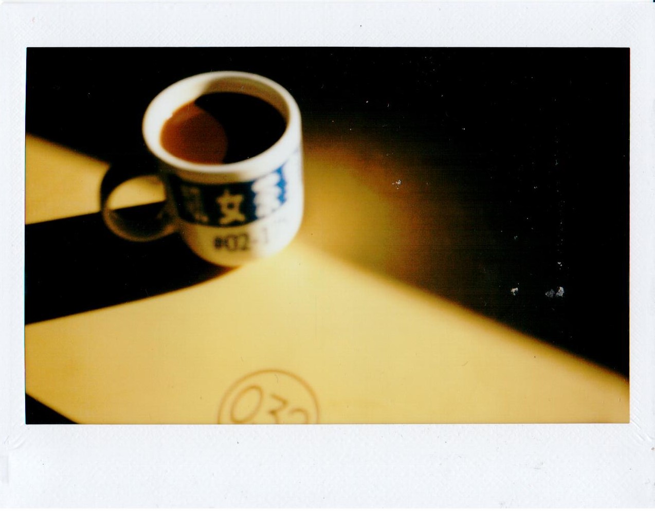 A cup of kopi on a sunlit table
