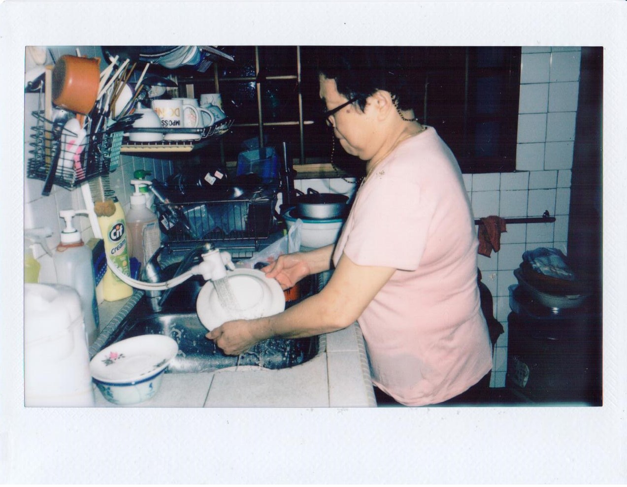 A woman washing dishes in a kitchen