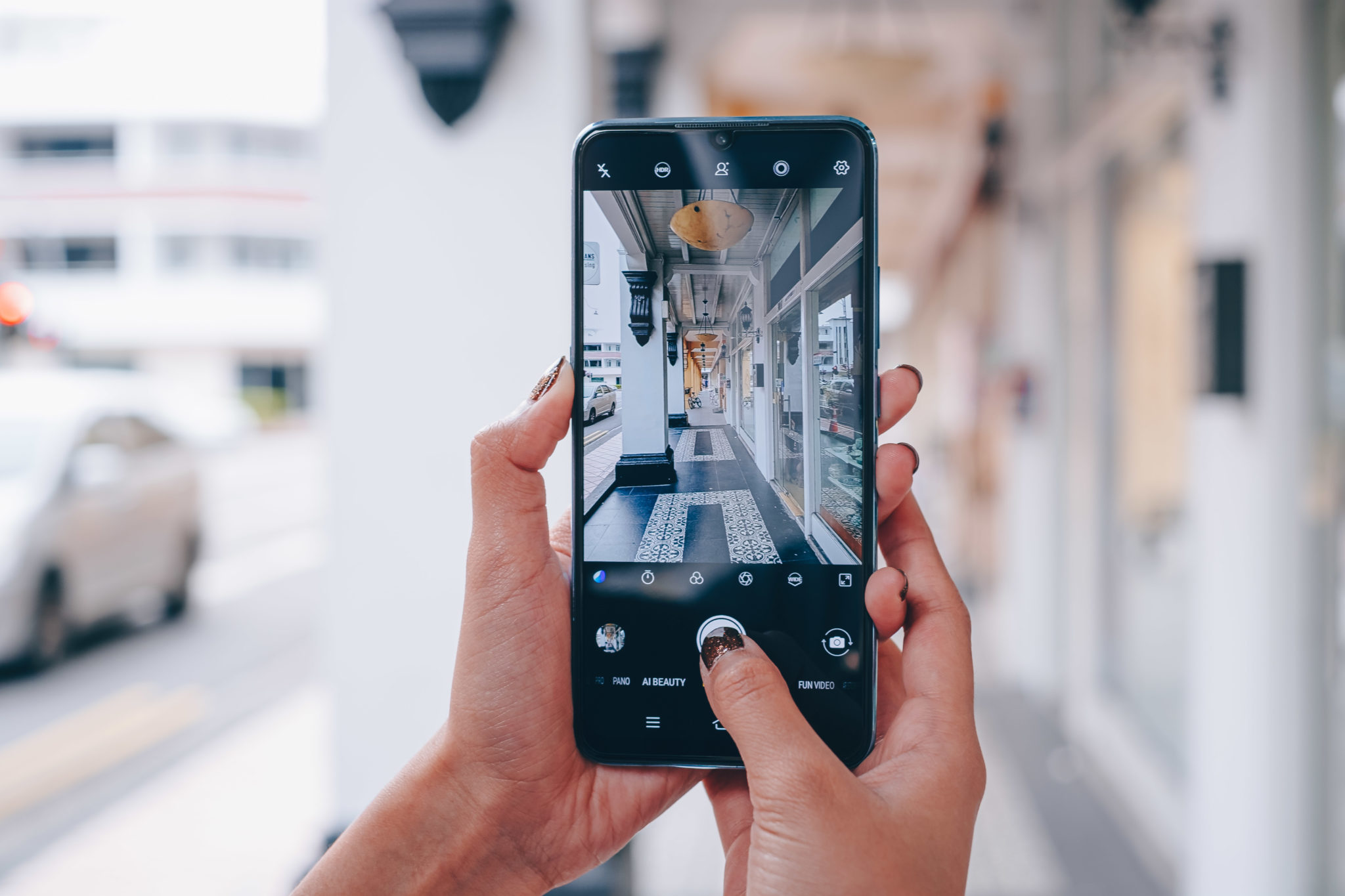 Hands holding the Vivo S1 with its camera app open on a street