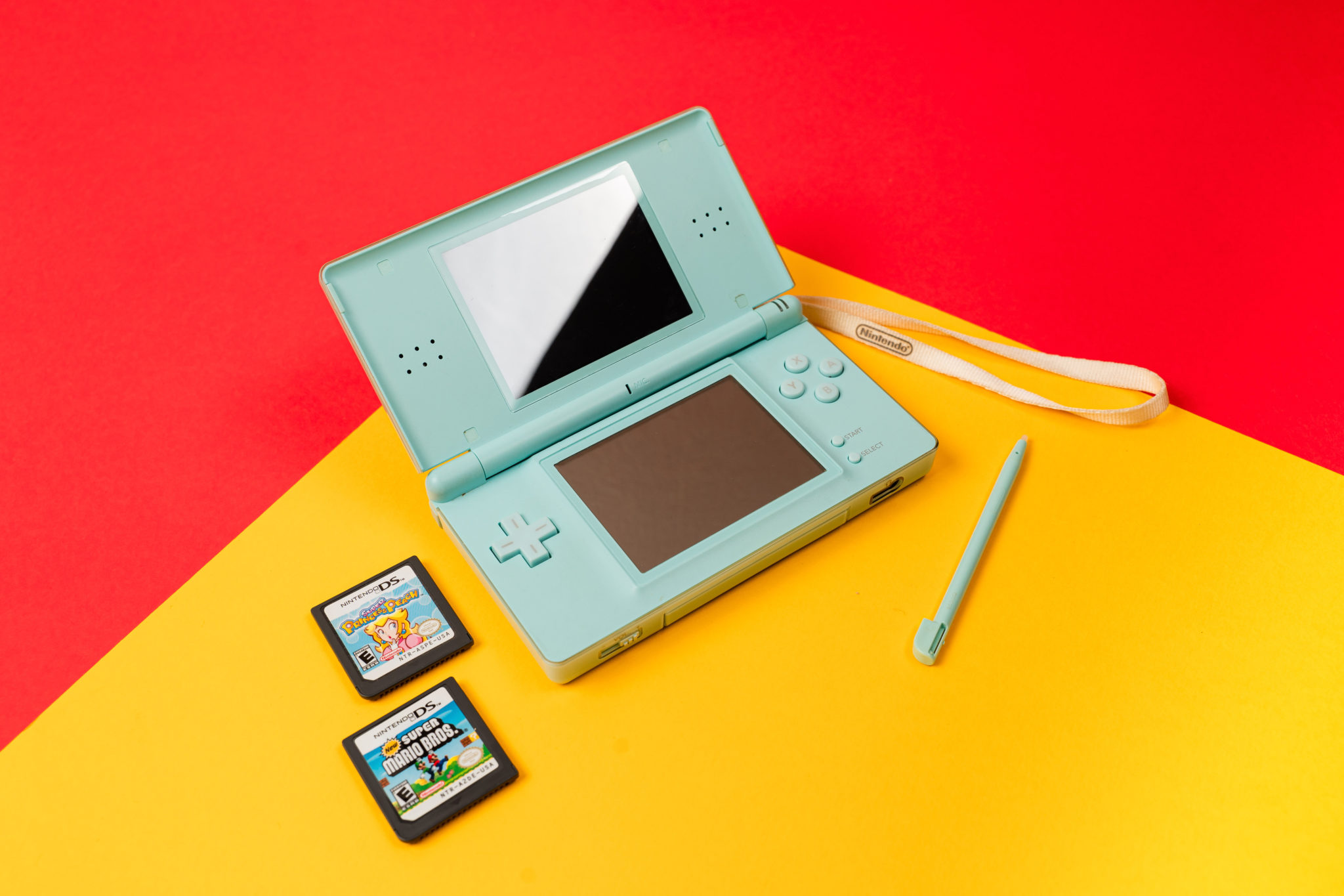 A Nintendo DS with its stylus and game cartridges