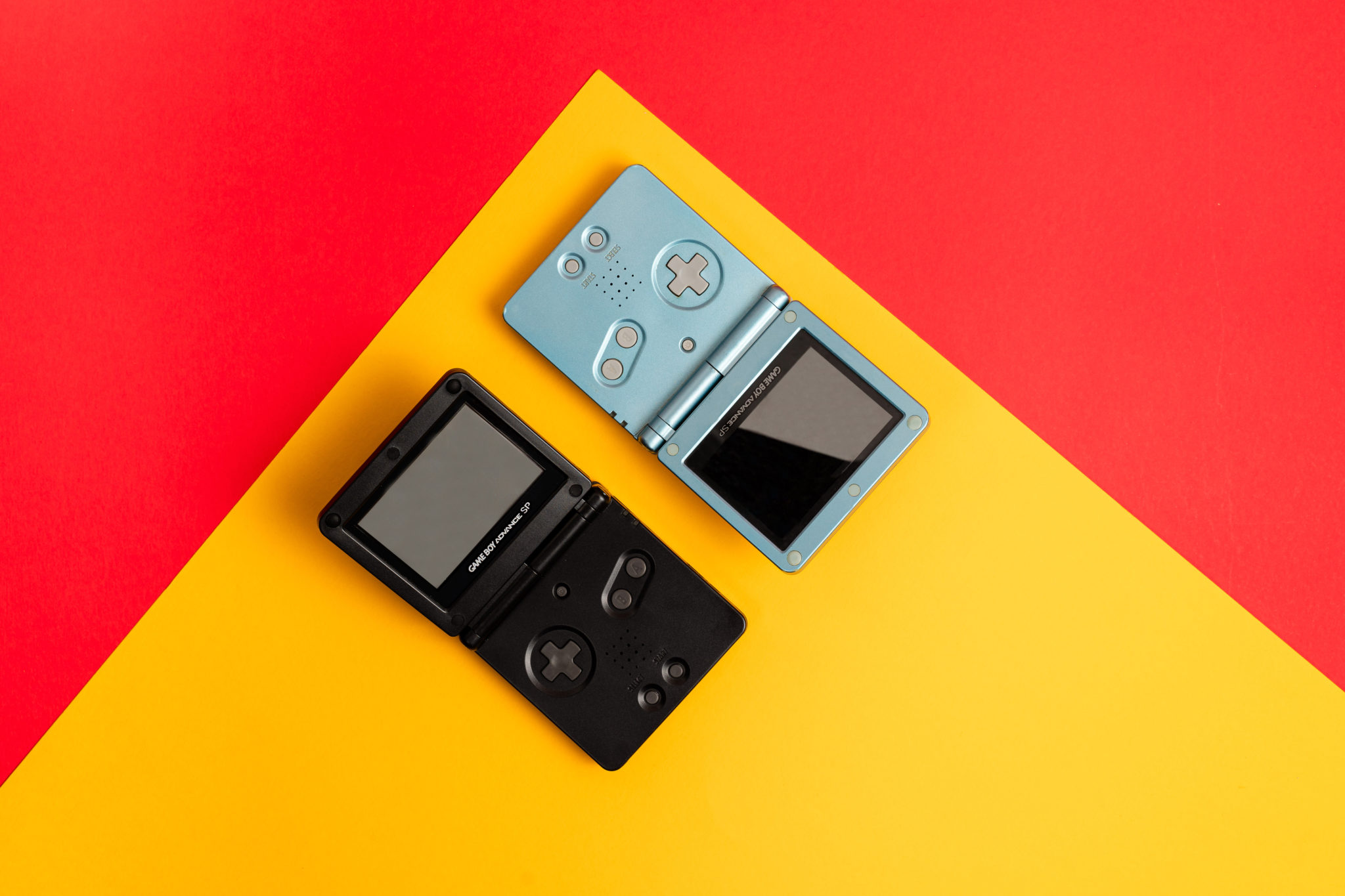 Two Game Boy Advance SP consoles, one black and one pale blue