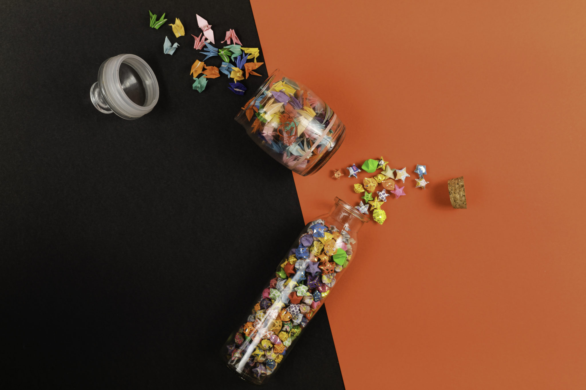 Small glass jars spilling colourful folded stars and trinkets