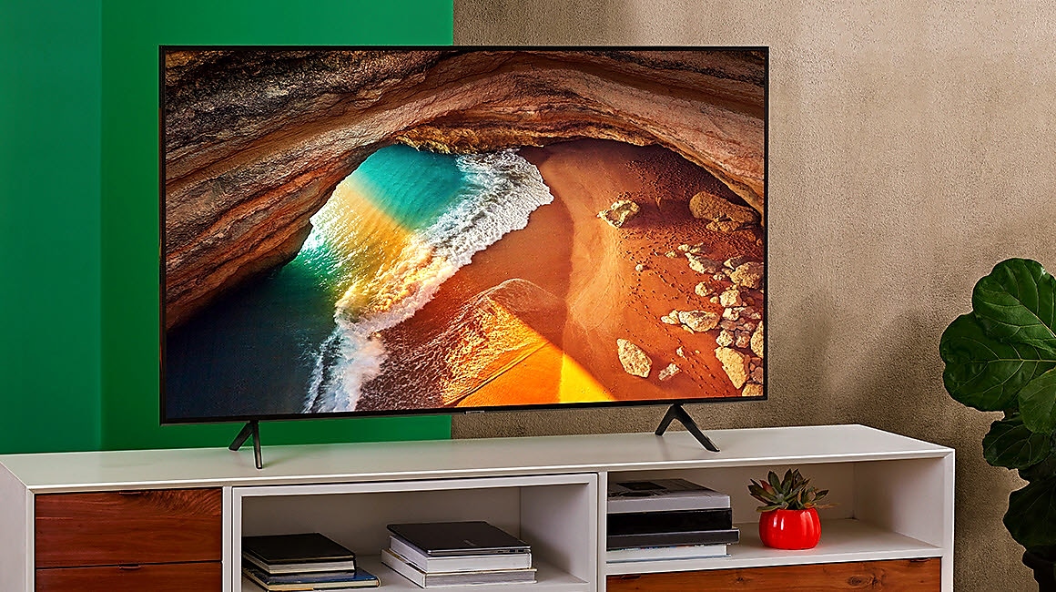 A Samsung QLED 4K TV on a white cabinet in a living room