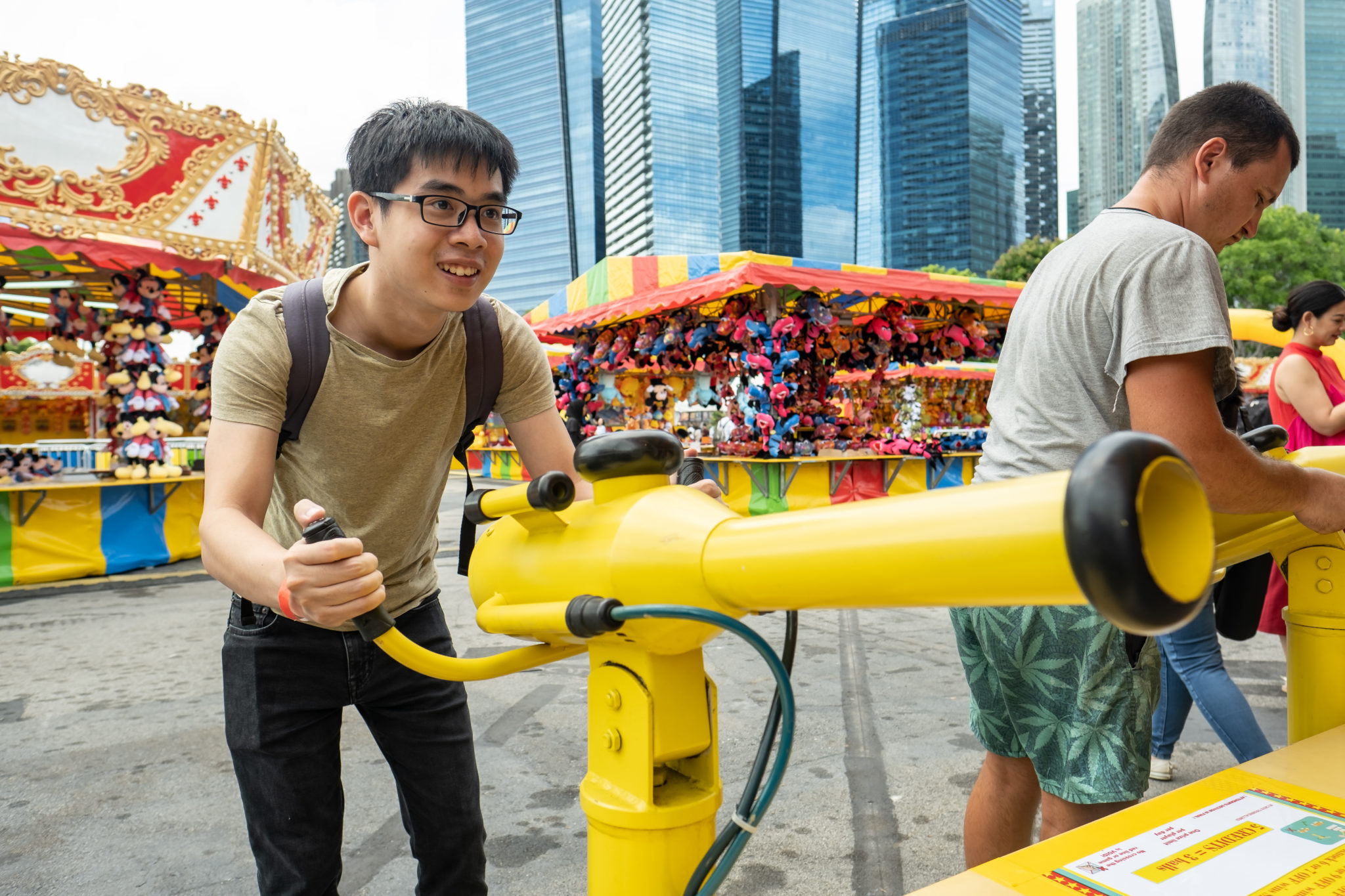 A visitor aiming a yellow air gun at the Uncle Ringo carnival