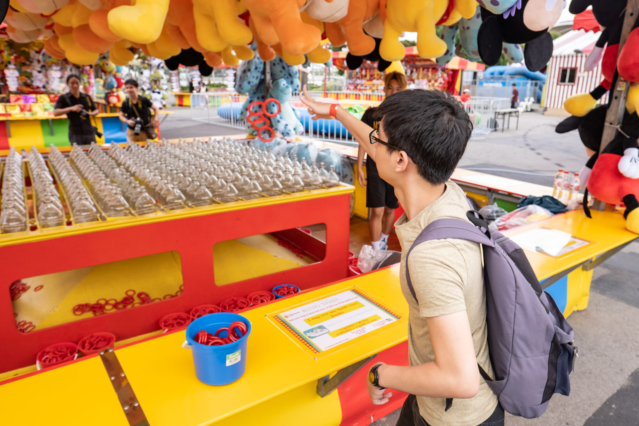 A visitor at a prize stall with rows of cups at the Uncle Ringo carnival
