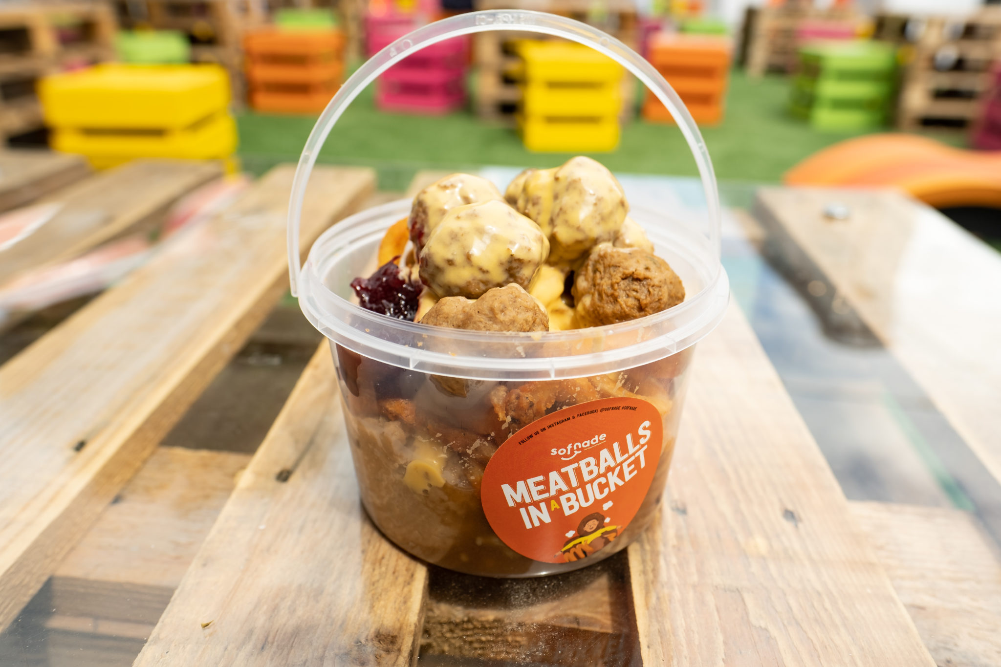 A bucket of meatballs with curly fries and mash