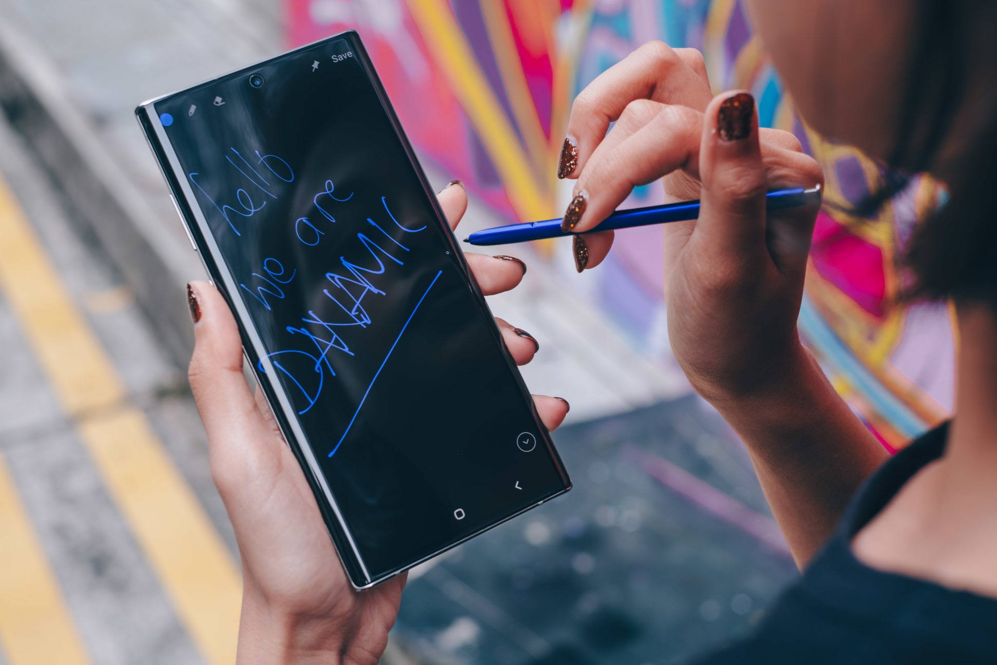 A person writing on the Note 10+ screen with the S Pen