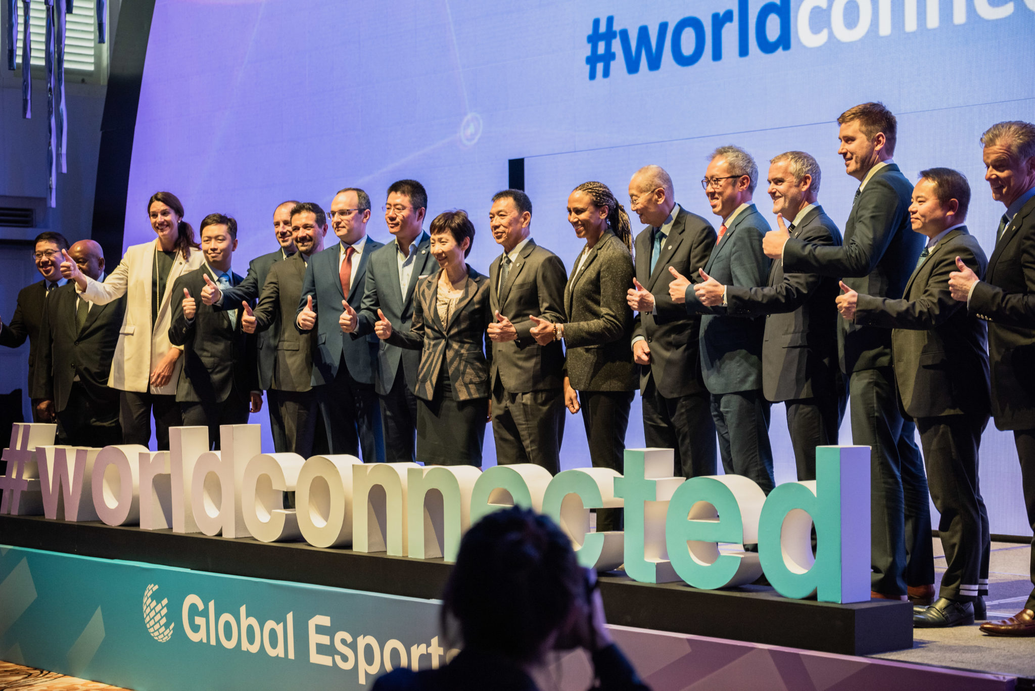 Officials lined up on stage at the Global Esports Federation launch behind a #worldconnected sign