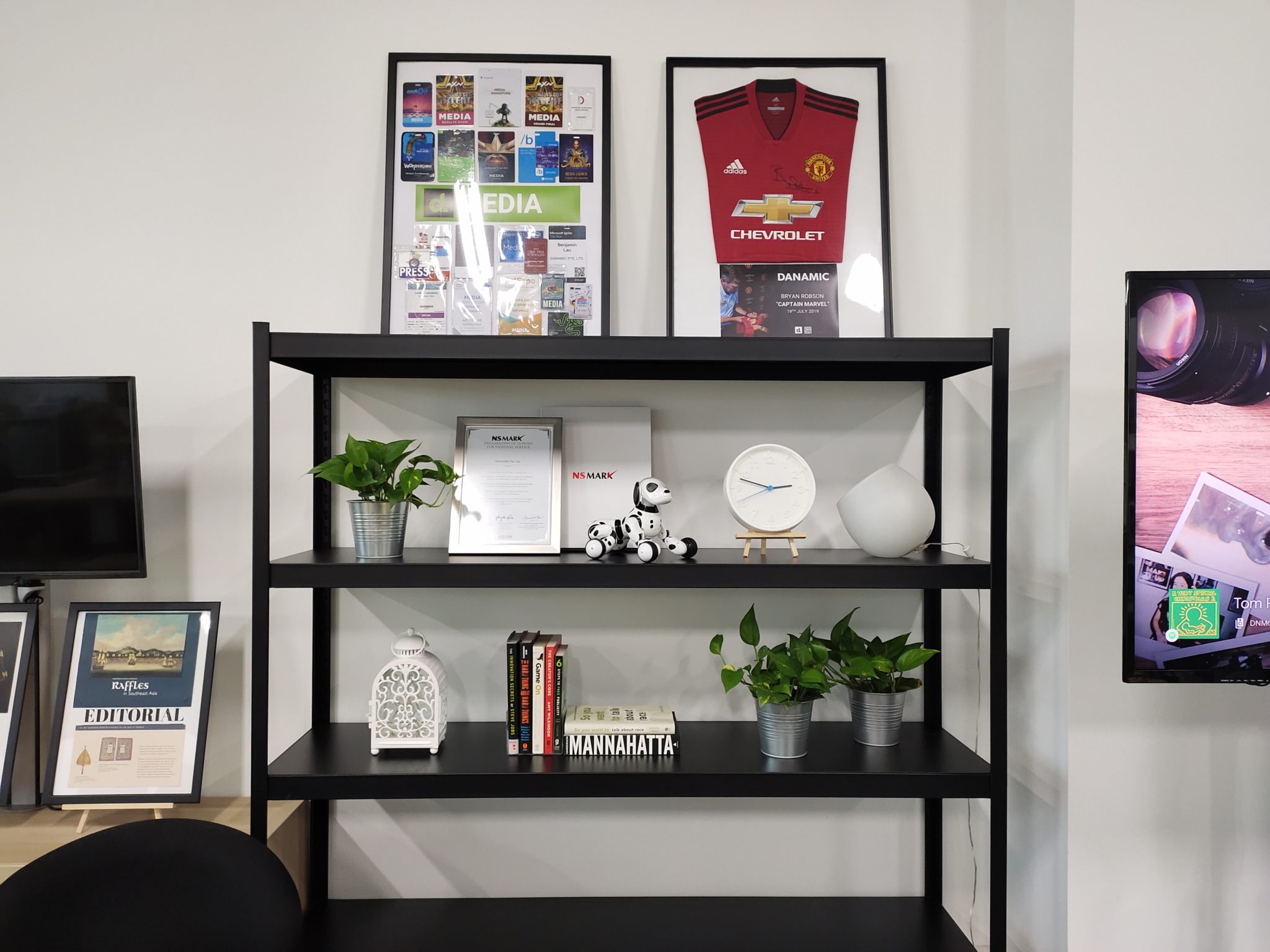 A shelf with framed items and a football shirt at the standard 1x zoom