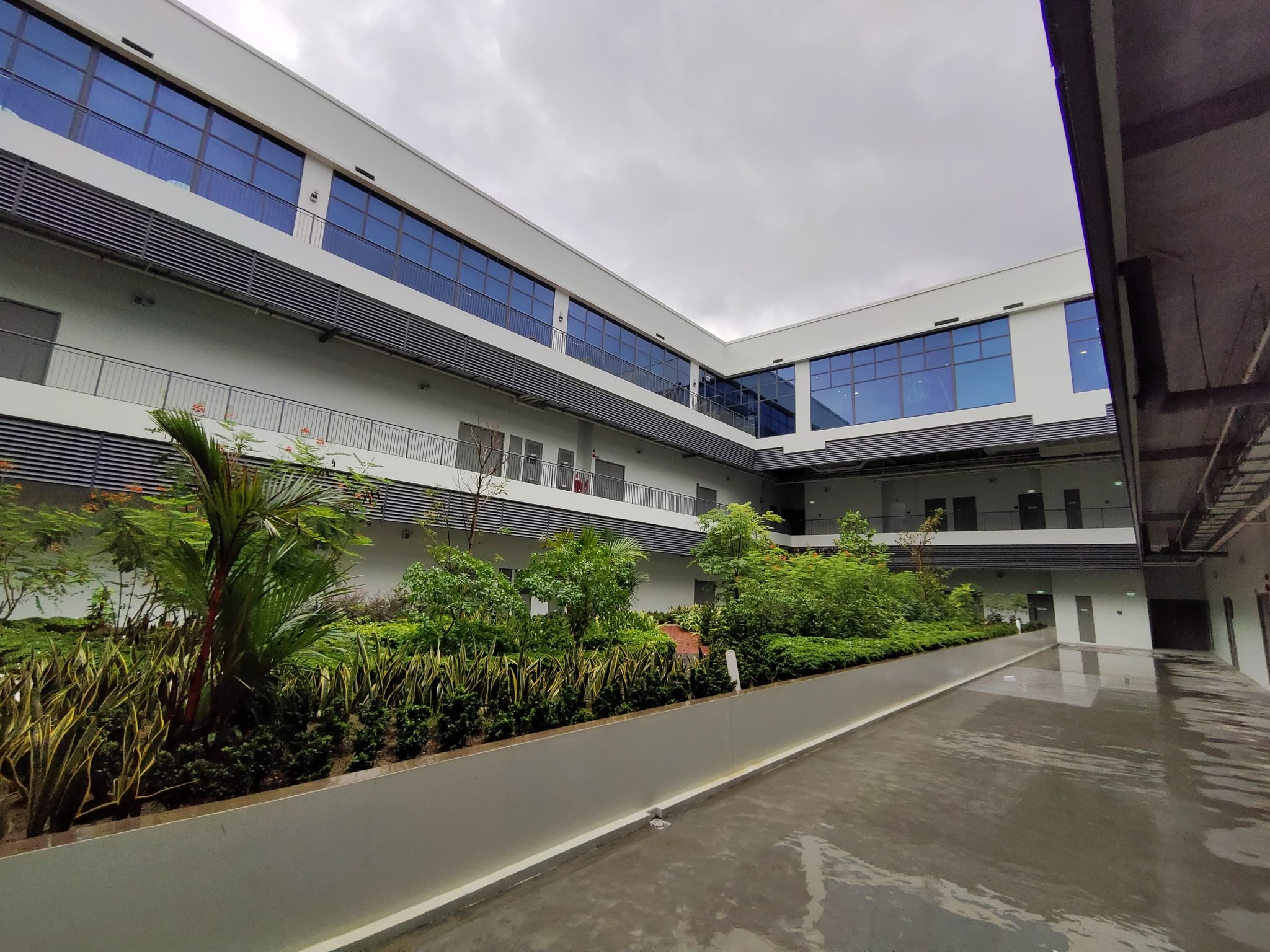 An ultra-wide shot of the same courtyard with the building leaning in at the edges