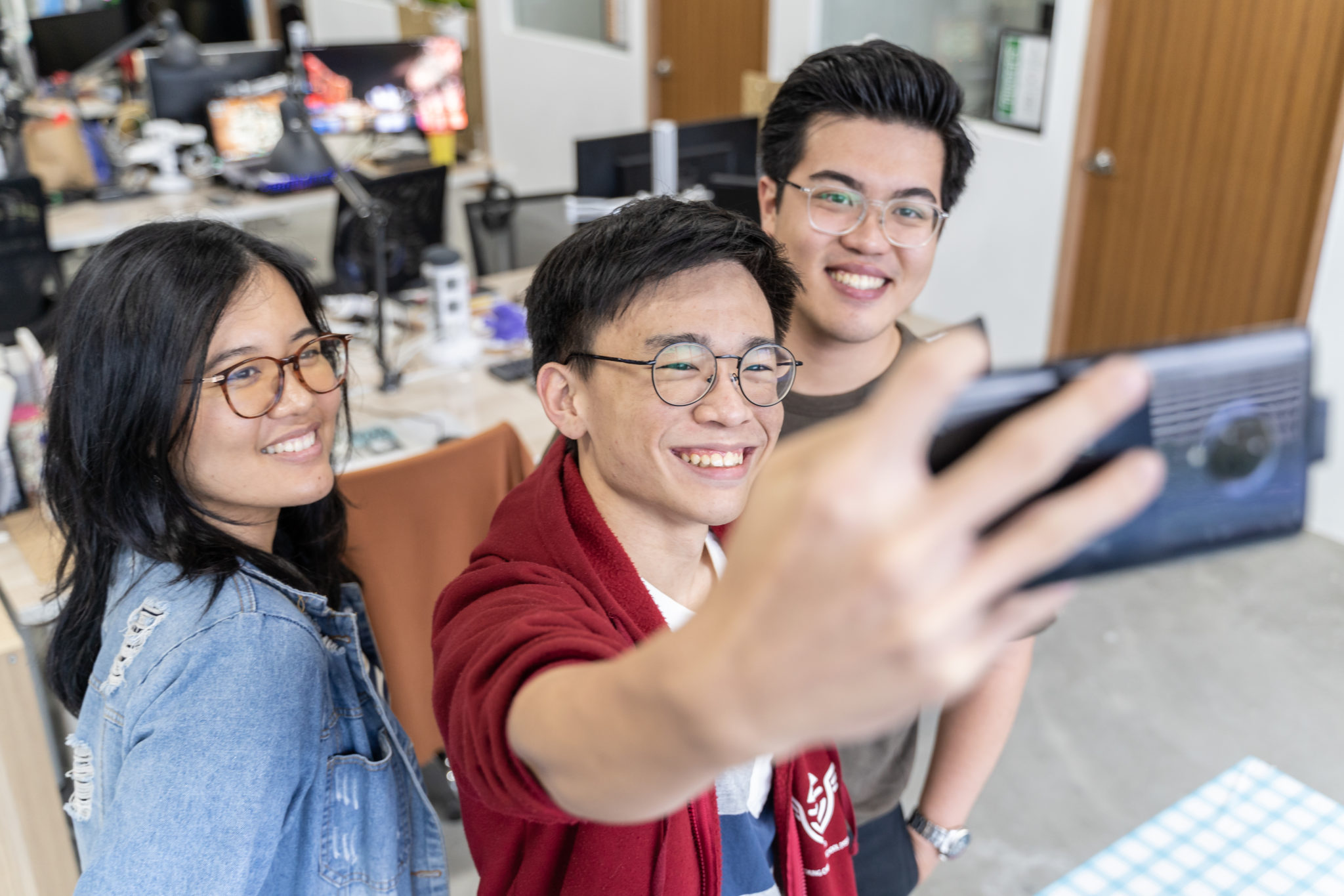 Three colleagues taking a group selfie with the Vivo Nex 3