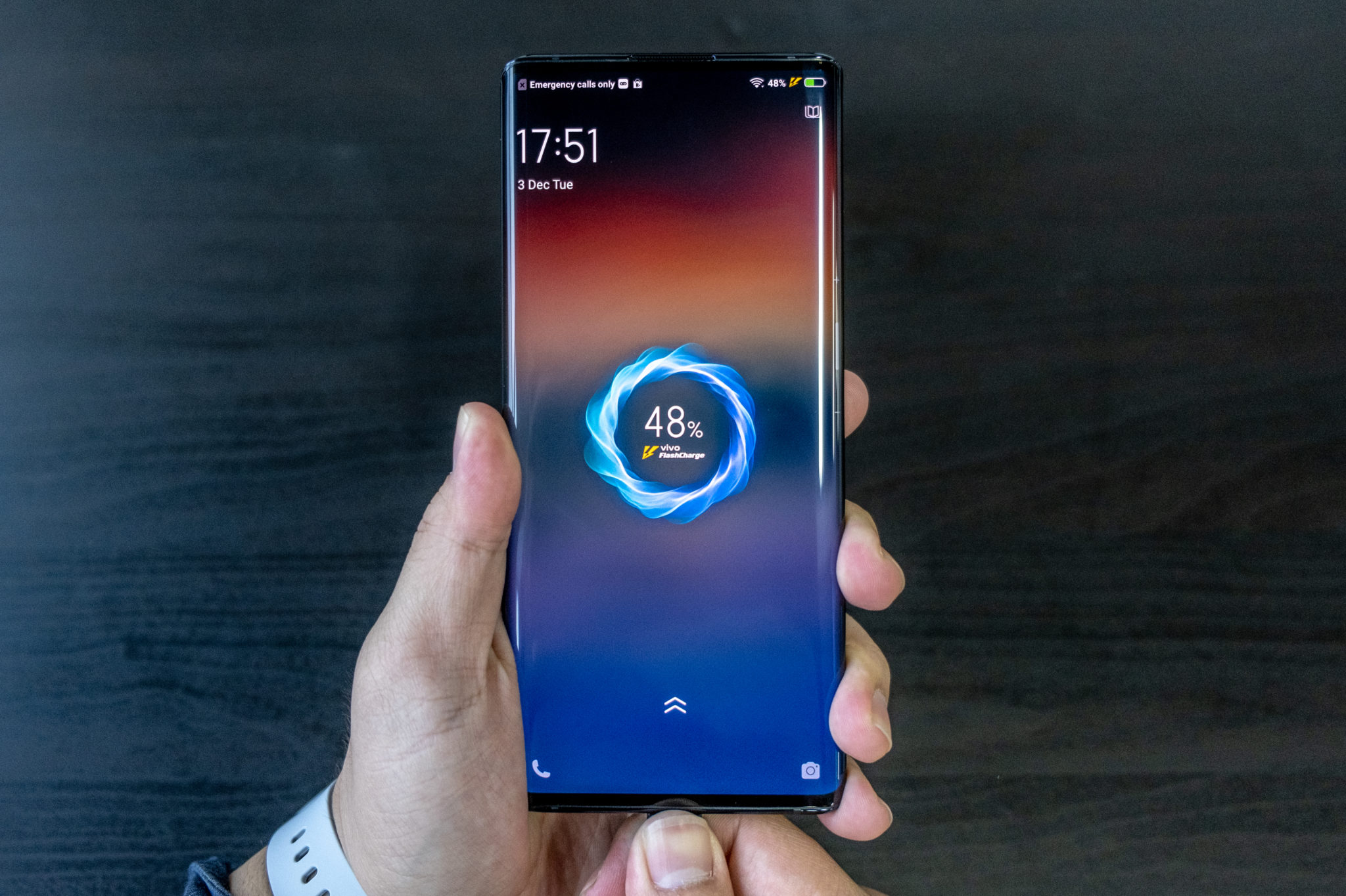 A hand holding the Vivo Nex 3 showing its charging screen at 48 per cent