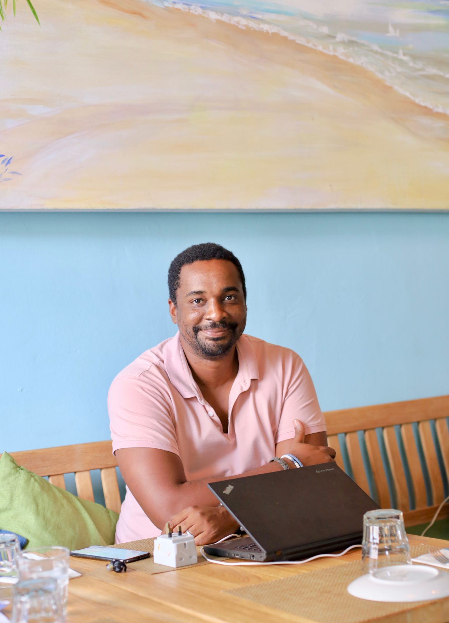 Chris Morris, founder and owner of Lime House, smiling at a table with a laptop