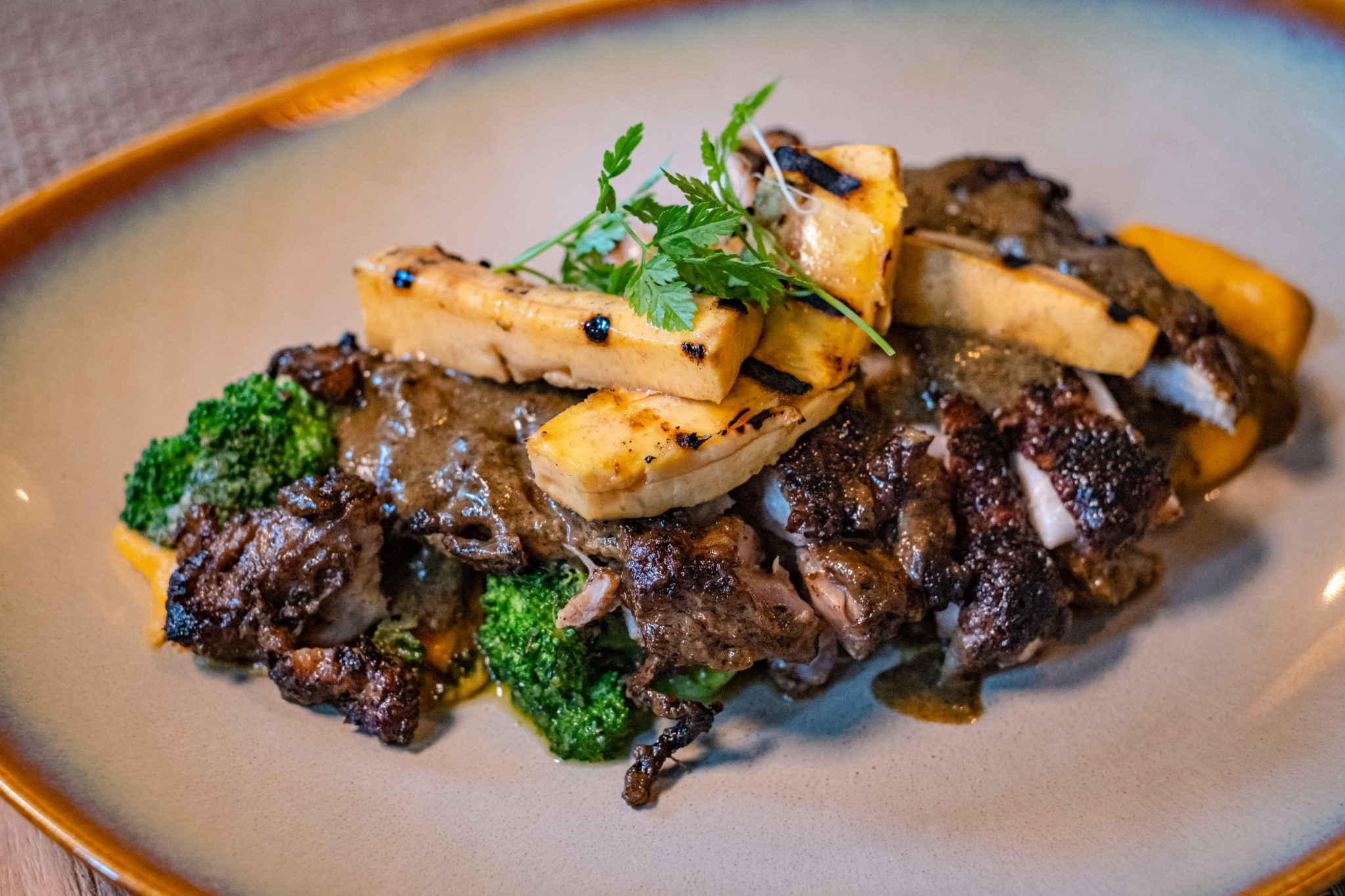 Sliced jerk chicken on a puree with greens