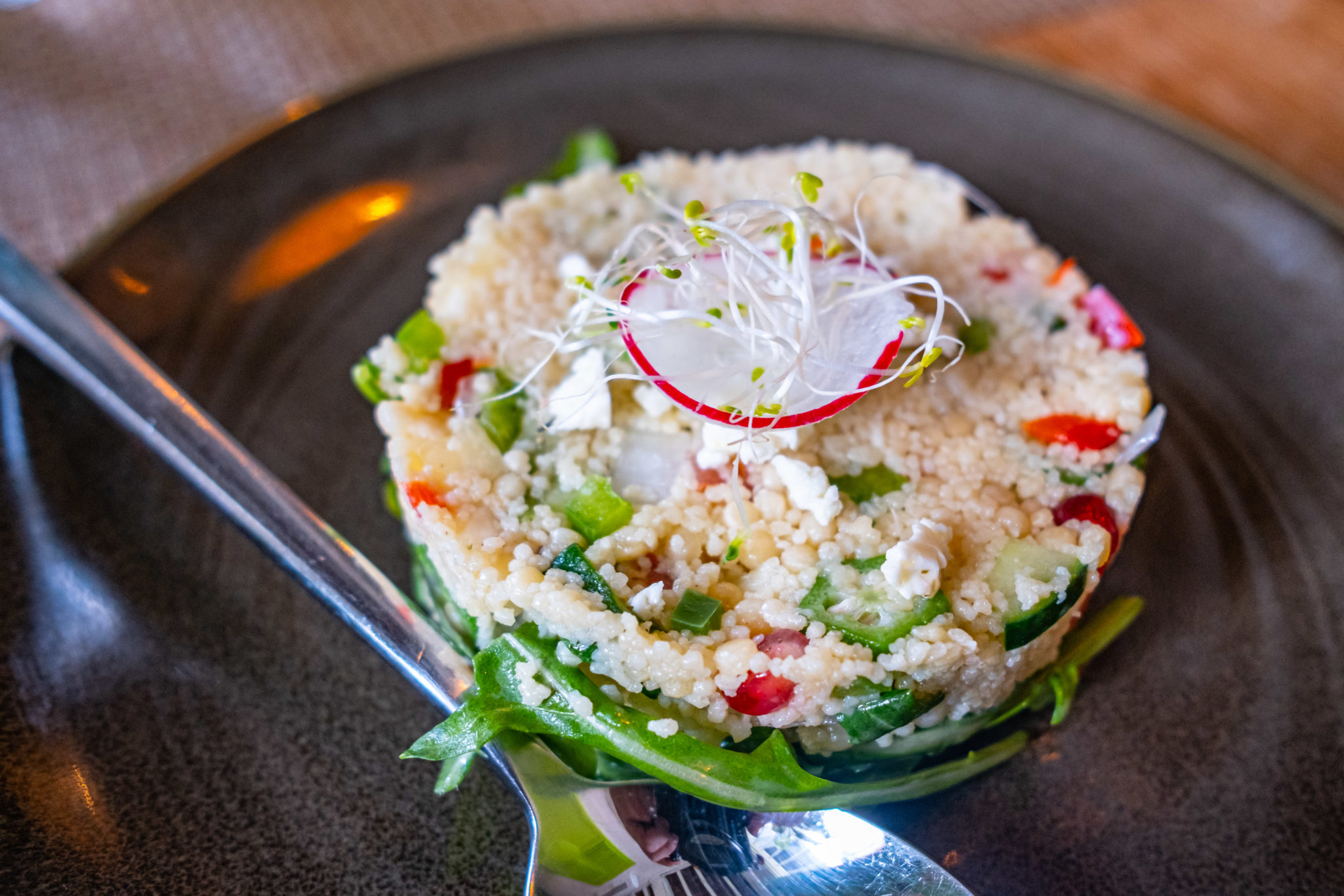 A tower of Caribbean couscous salad topped with sliced radish