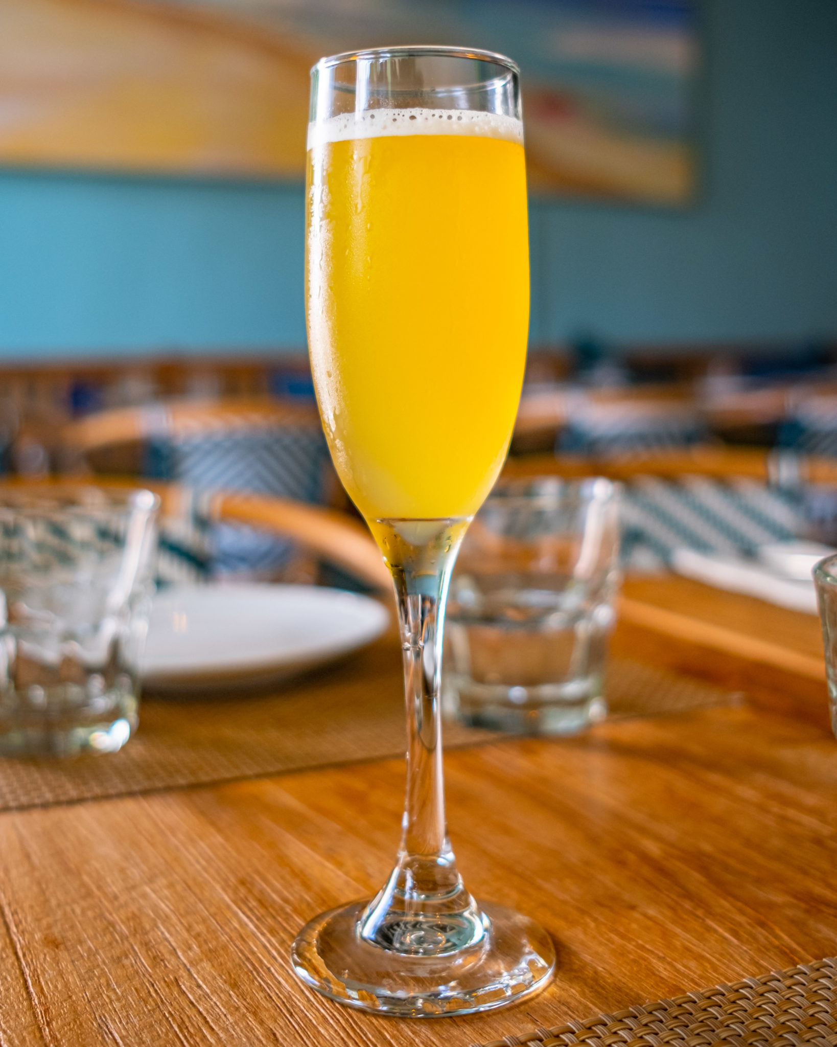 A flute of the AirMail cocktail on a wooden table