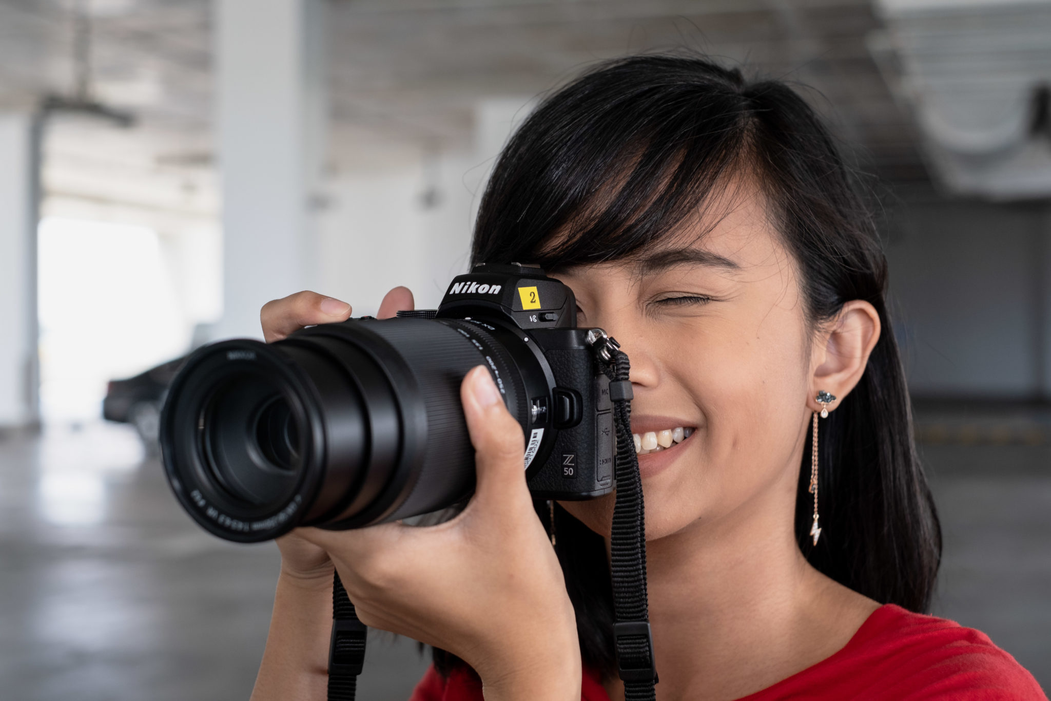 A photographer shooting with the Nikon Z 50 and a telephoto kit lens