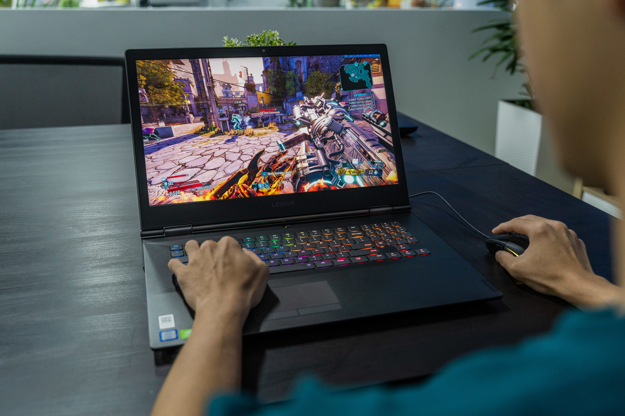 A person playing a game on a Lenovo Legion laptop with a mouse