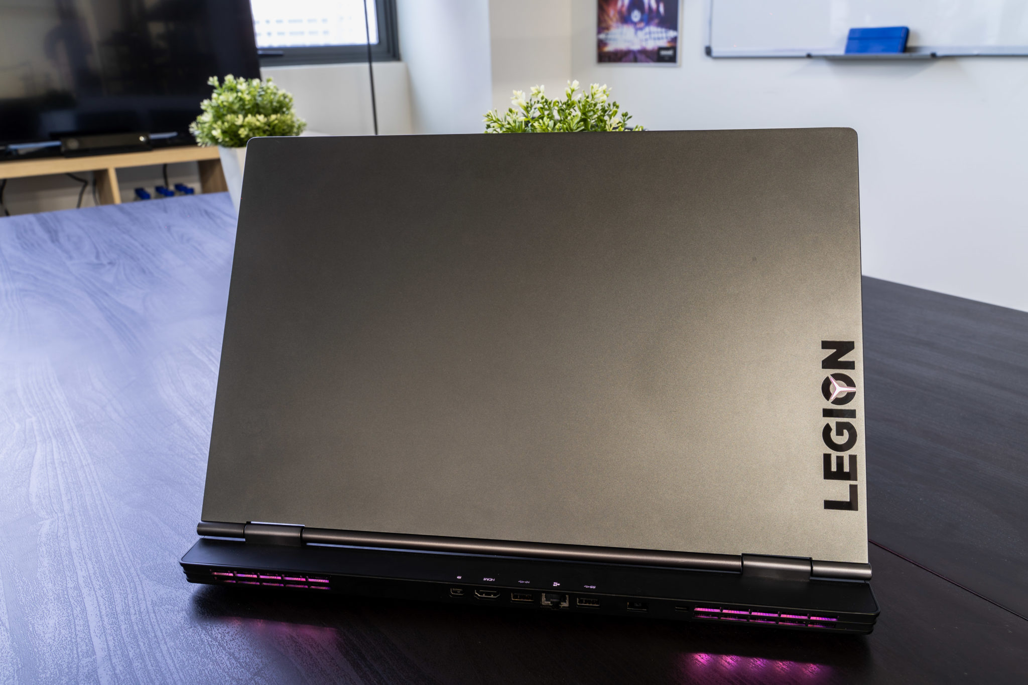 The lid of the Lenovo Legion Y740 with the Legion name down its edge and purple light at the vents