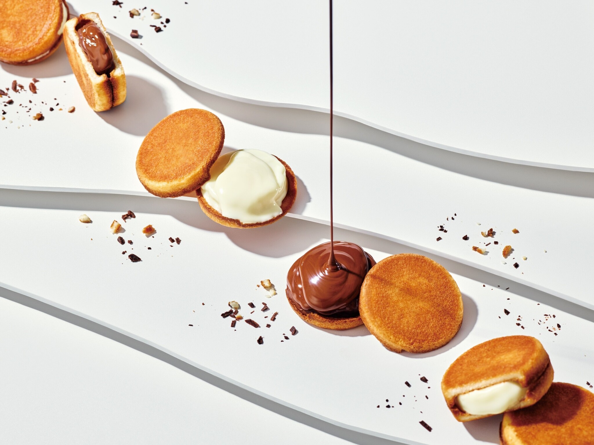 Chocolate-filled sandwich cookies are arranged for a product photograph.