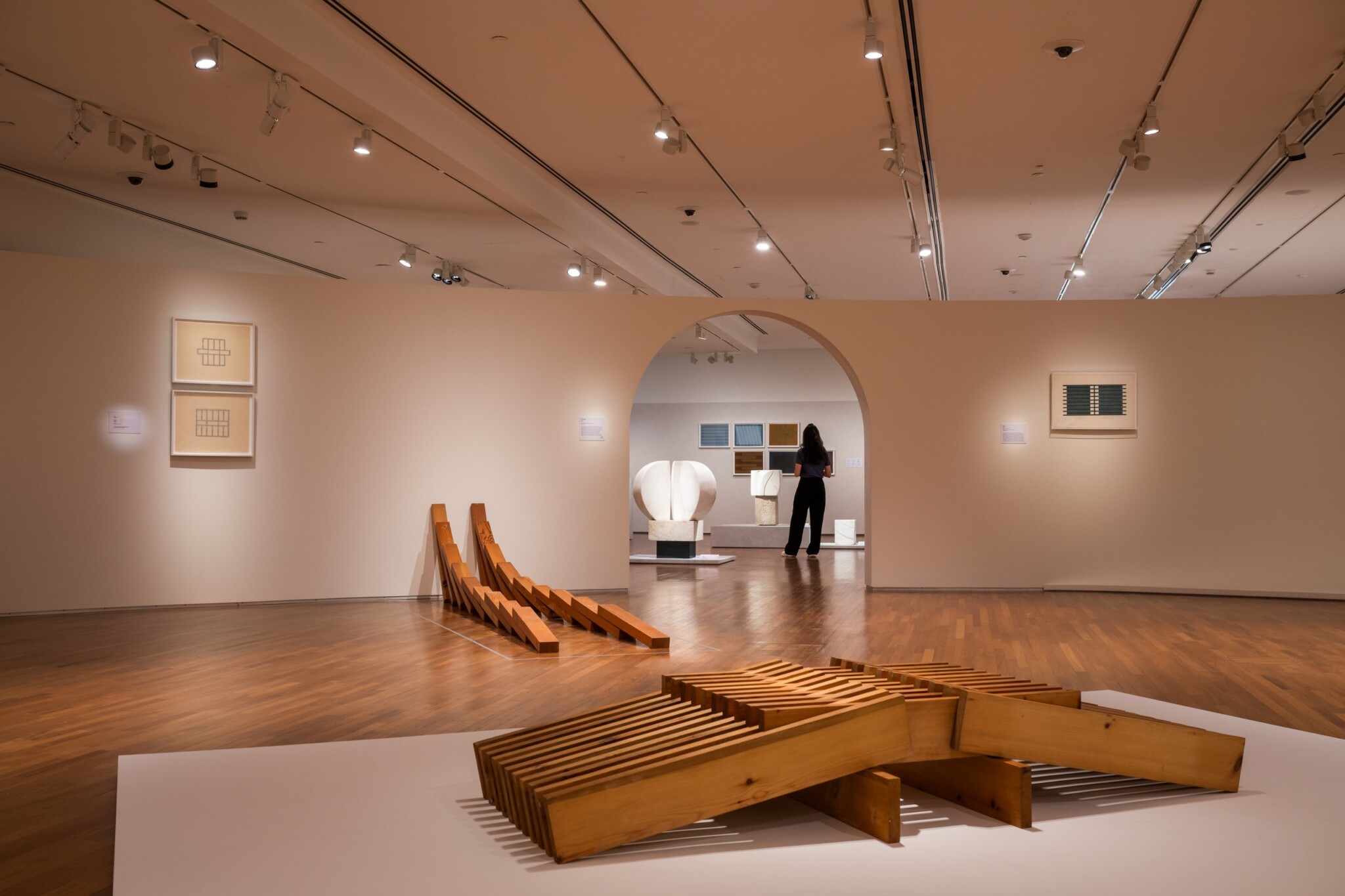 Sculptures and framed works are displayed in a bright gallery.