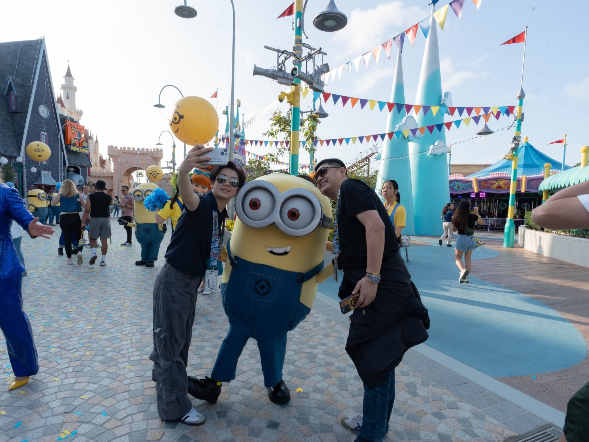 A visitor poses beside a costumed Minion character.