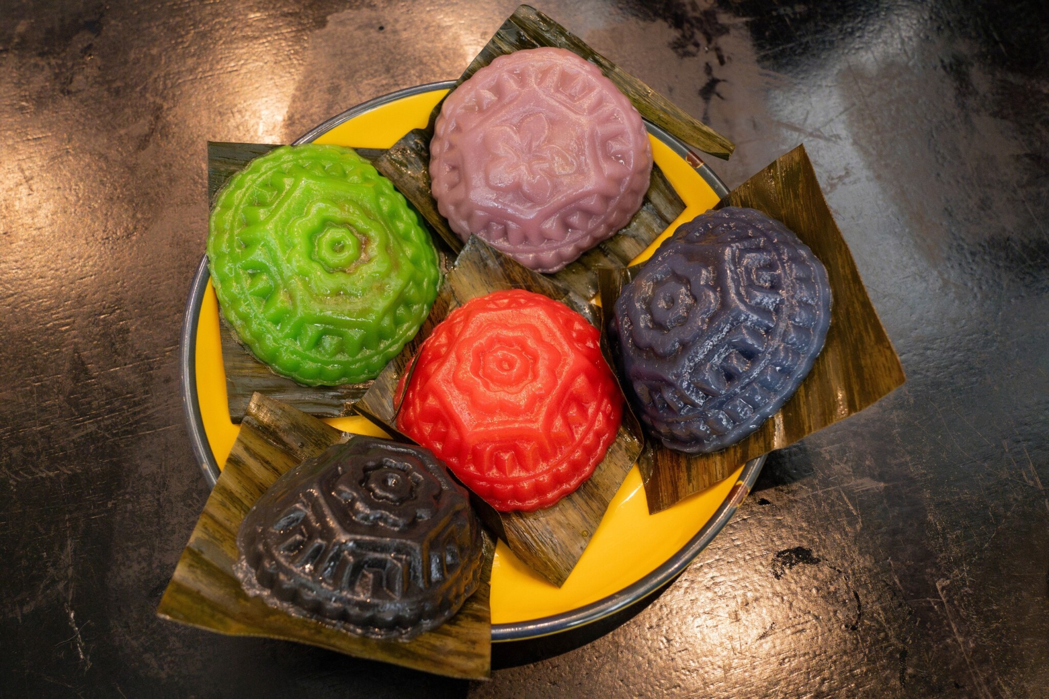 Colourful ang ku kueh are arranged on a plate.