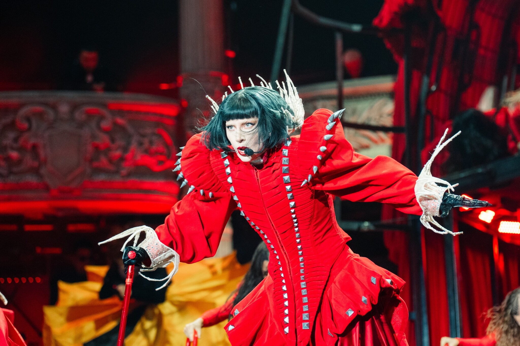 Lady Gaga performs on stage in a red costume at her Singapore concert.