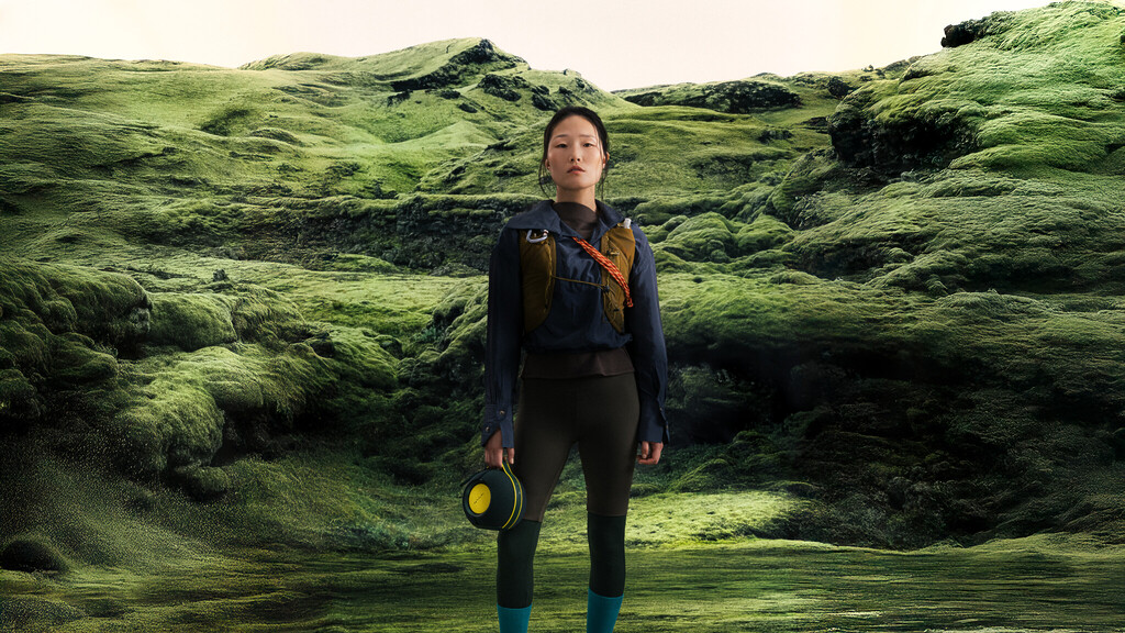 Devialet Mania Summer Moss Green with Cocoon on a Landscape.