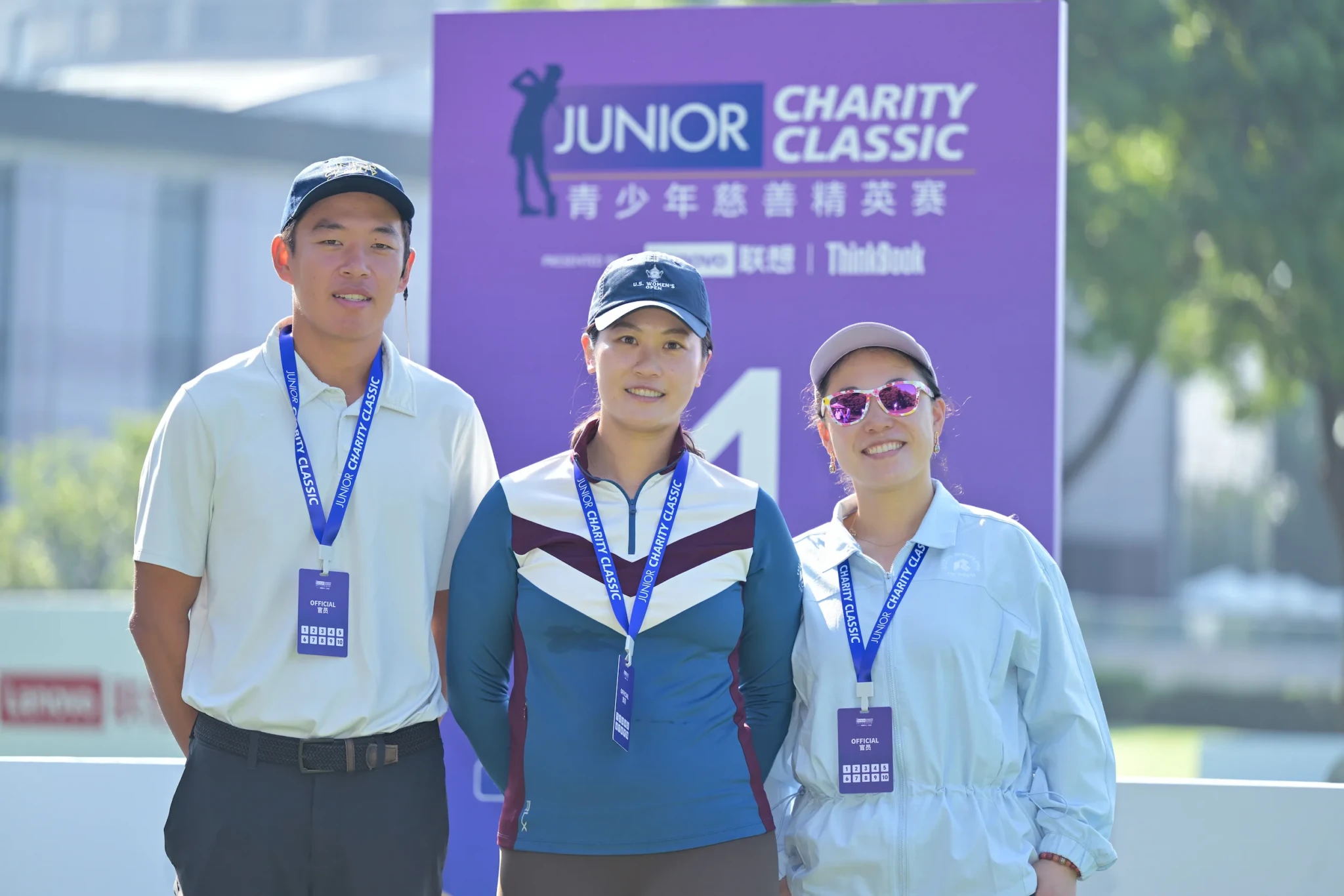 Officials pose in front of the Junior Charity Classic banner presented by Lenovo ThinkBook