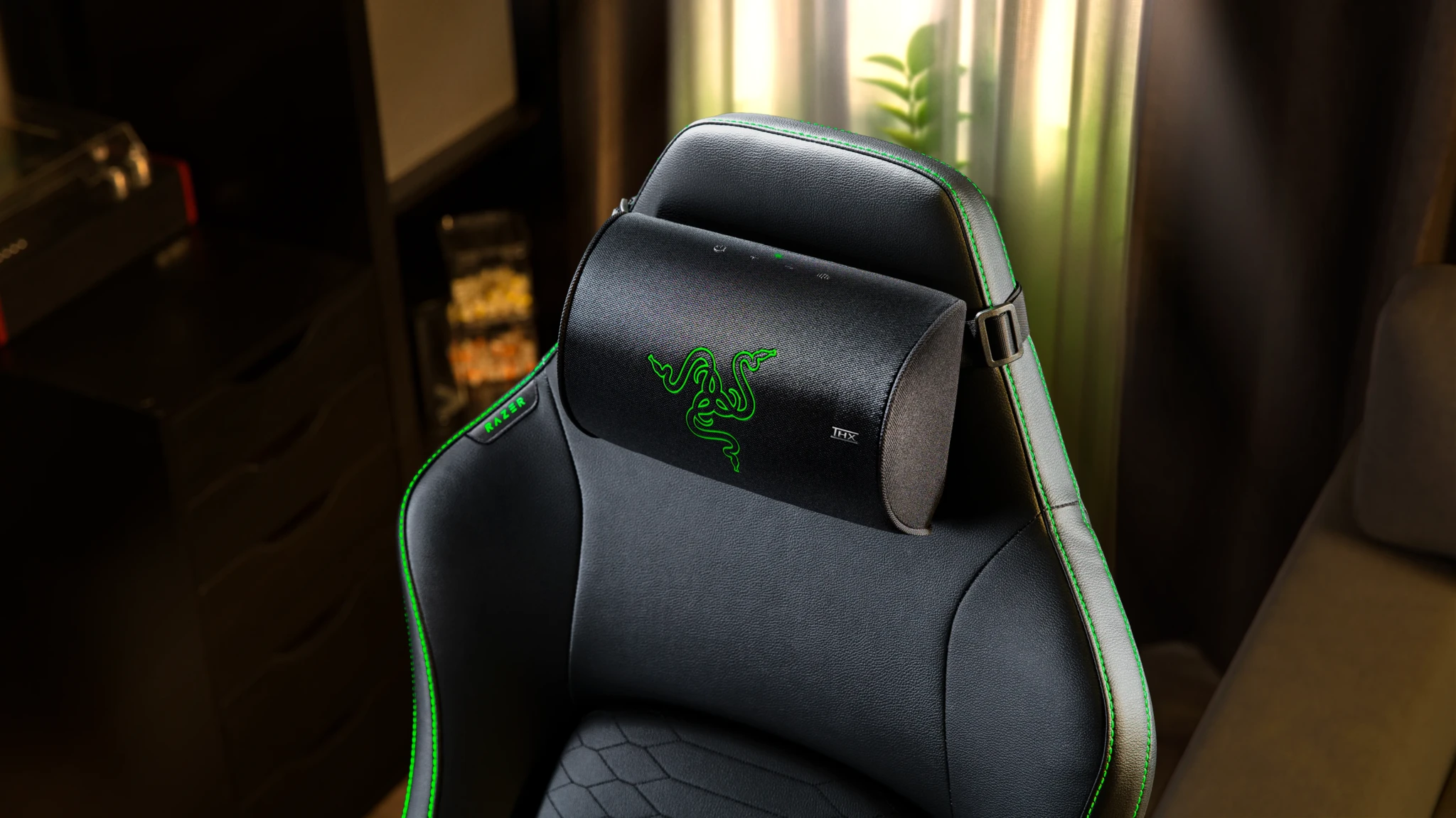 Razer gaming chair with black upholstery, green stitching, and the three snake logo on the headrest