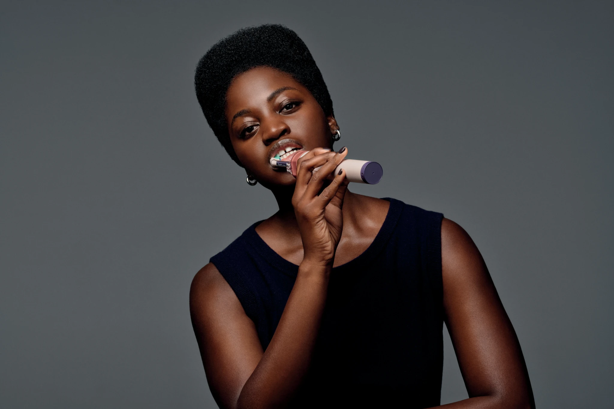 A person demonstrating the Dyson CameraJet toothbrush with its built-in camera