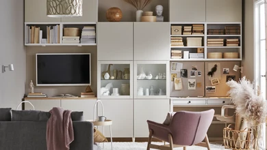 A modern living room with modular built-in shelving, a wall-mounted television and neutral furnishings