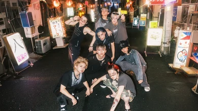 ONE OR EIGHT, the eight-member group behind the Black Clover 2nd Season ending theme, posing on a Japanese street