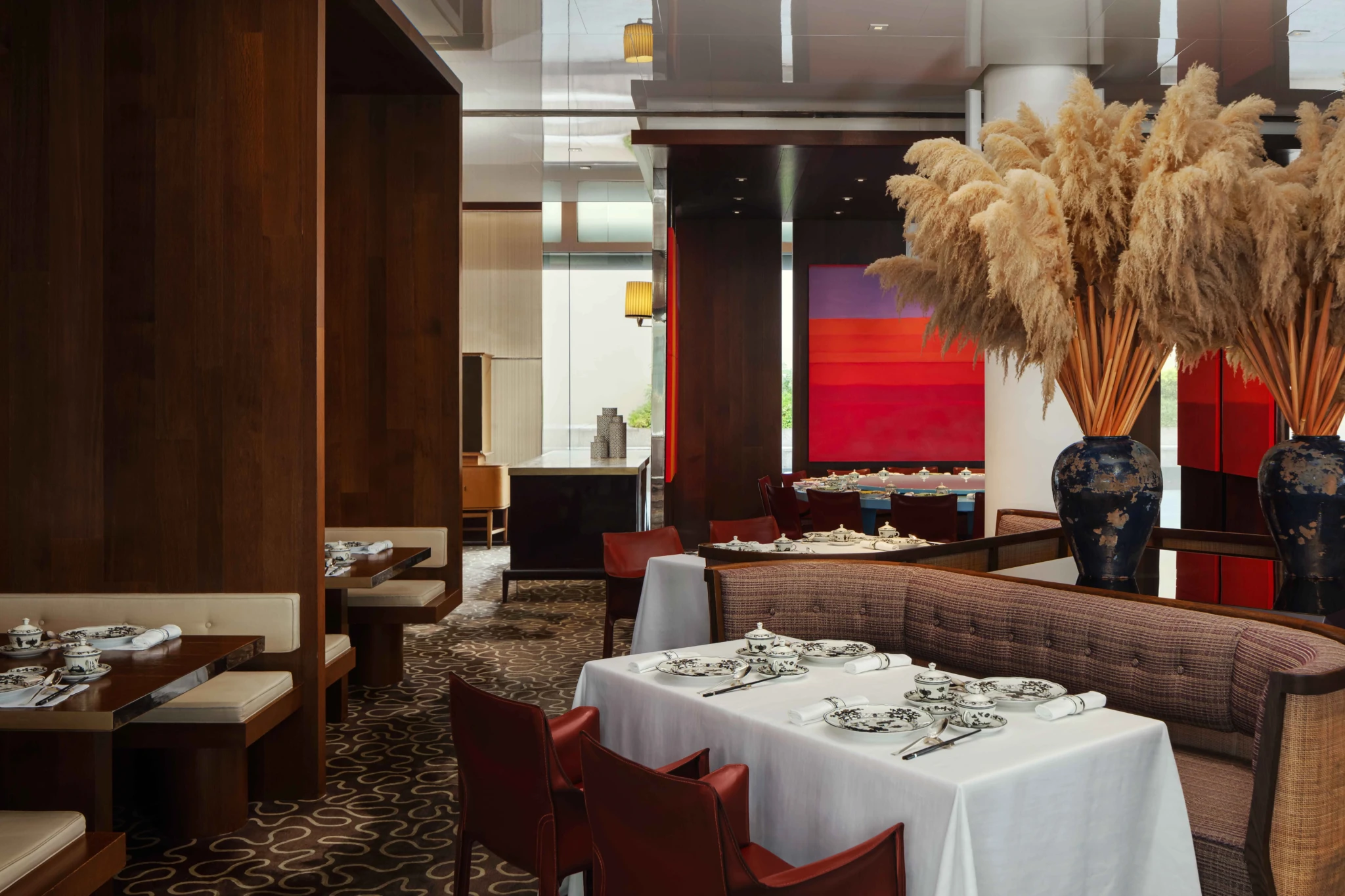 The dining room at Summer Pavilion set with contemporary wood panelling and pampas grass arrangements