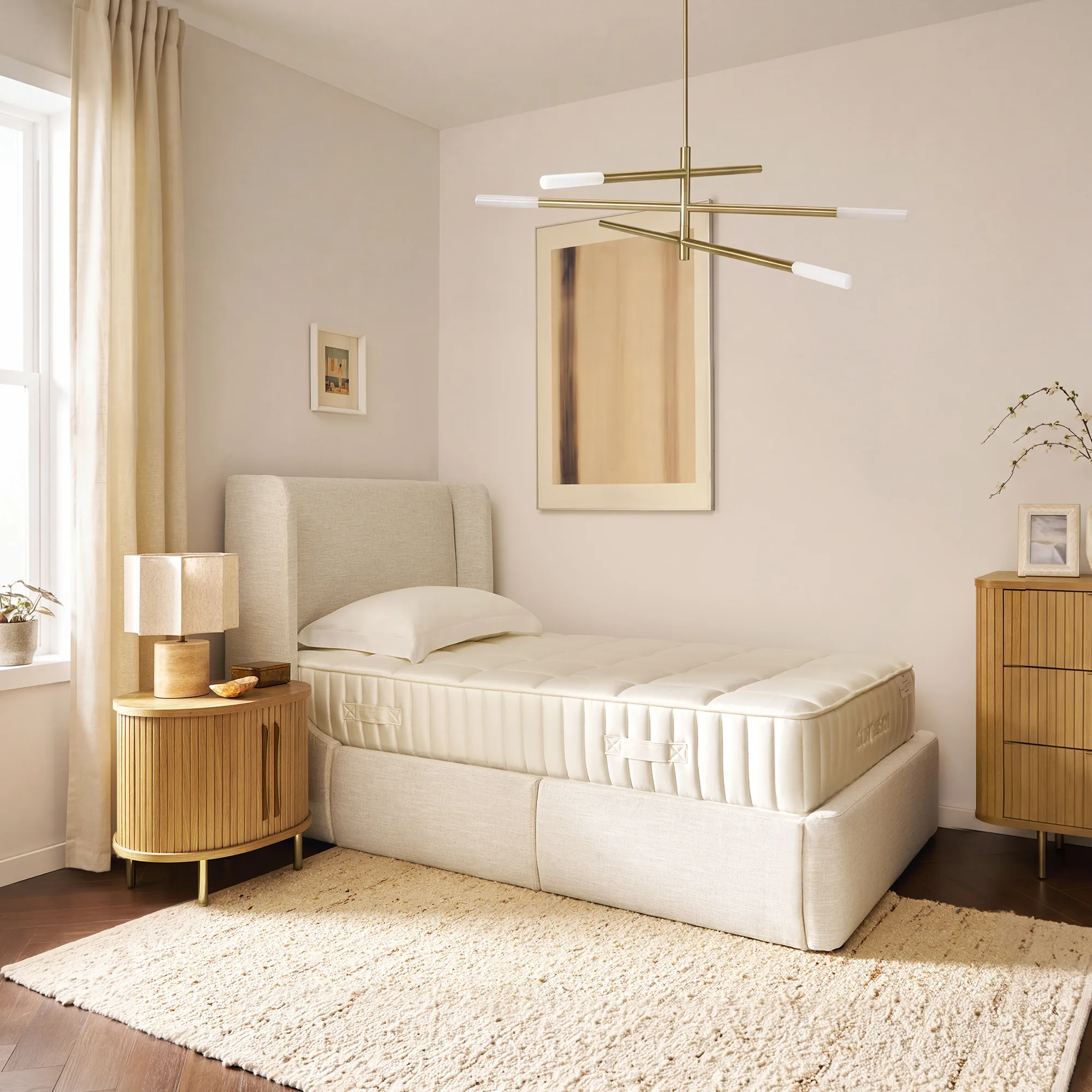 The Ayrie Mattress in a modern bedroom with cream upholstery and brass lighting