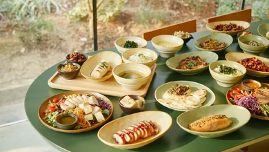 A full Nourish Plate spread at Shared Table, with dishes in white bowls on a teal table
