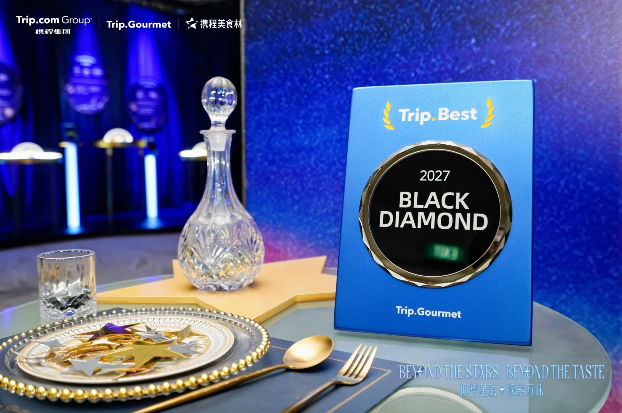 Trip.Gourmet 2027 Black Diamond award plaque on a fine dining table with a crystal decanter and gold-rimmed dinnerware