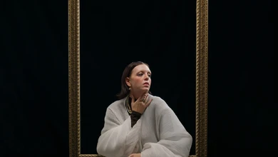 googly eyes posed inside an ornate golden frame, gazing upward, against a dark background