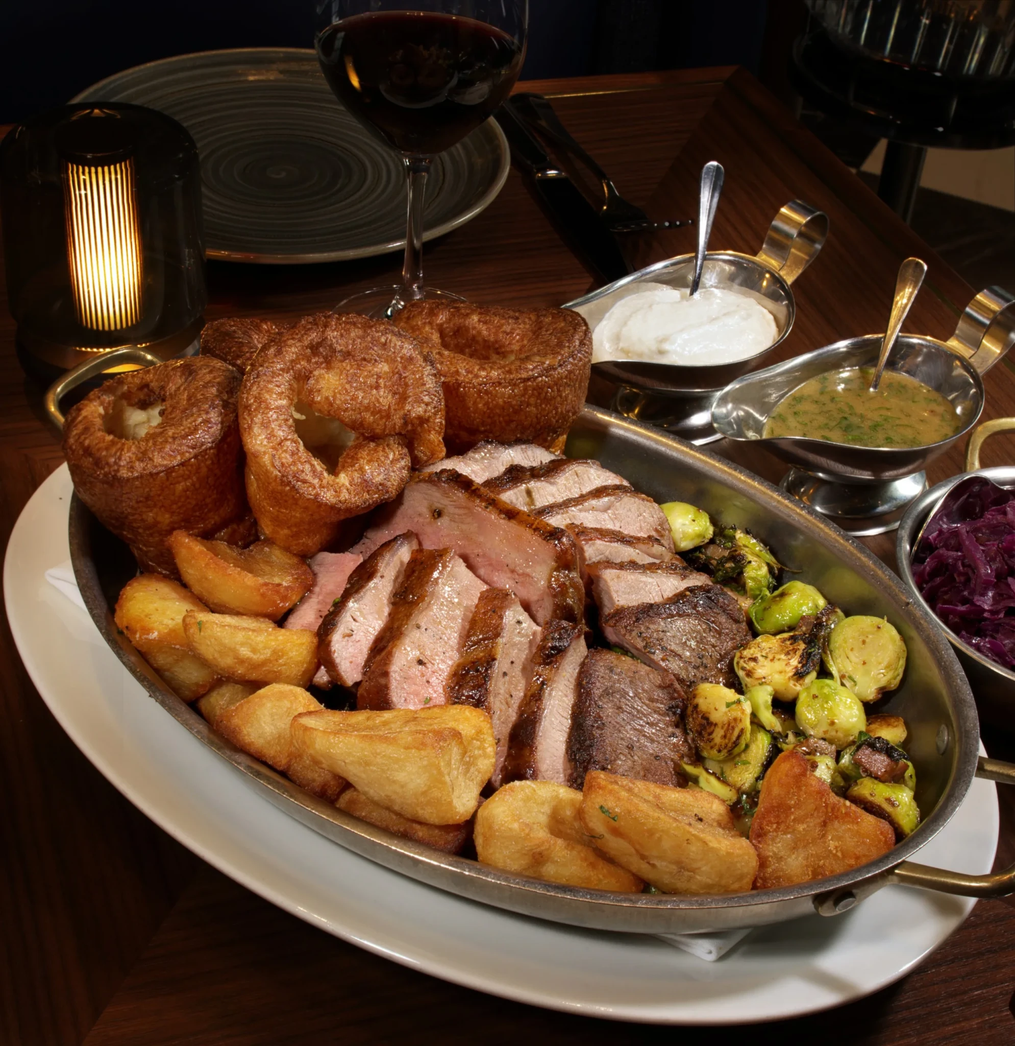Roast beef, Yorkshire puddings, potatoes and Brussels sprouts served with gravies