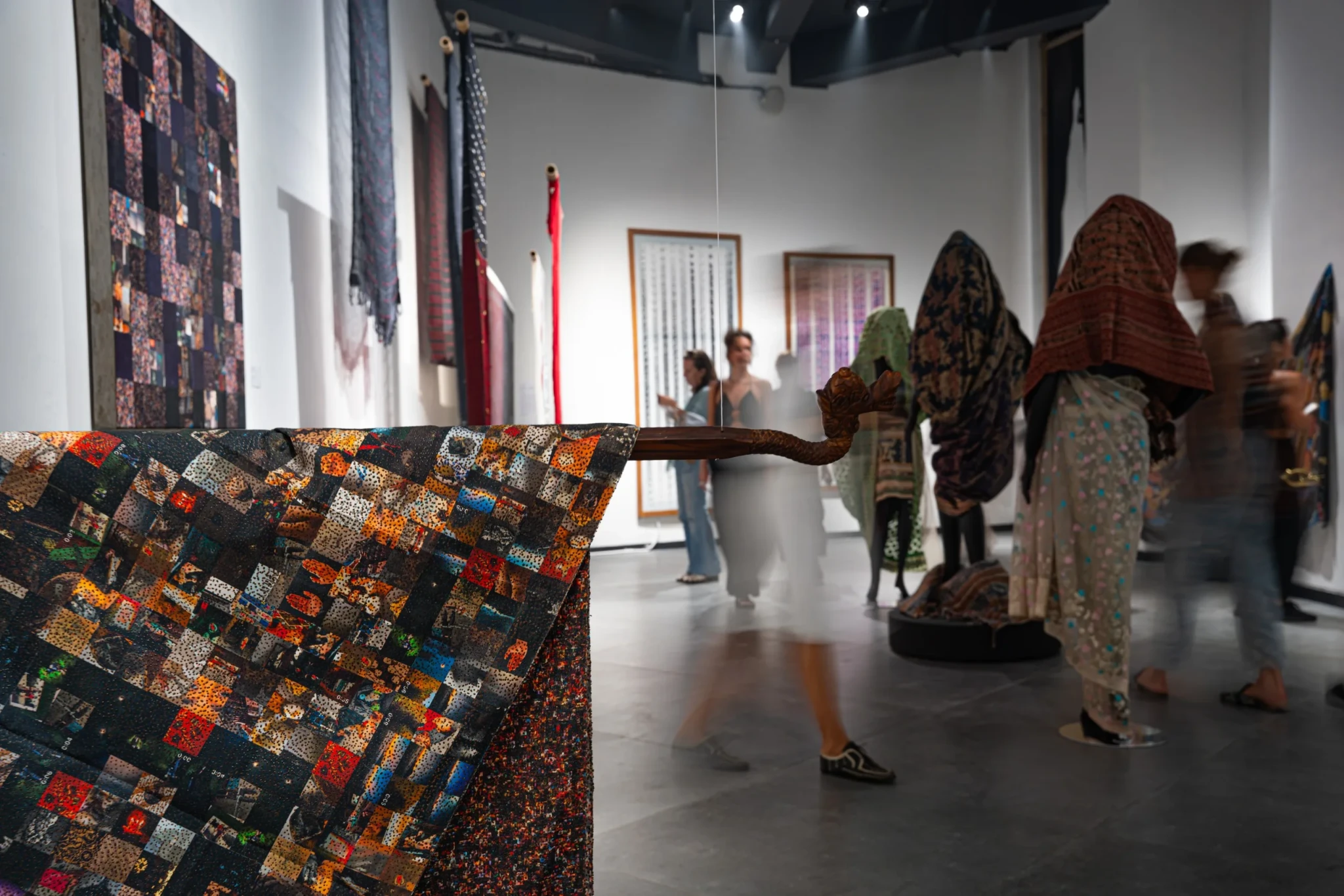 Textile installations and mixed-media artworks arranged in the exhibition gallery
