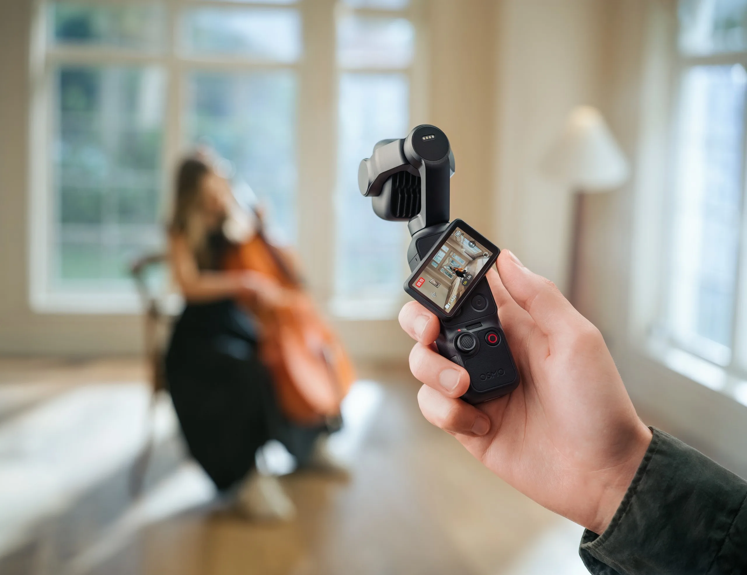 A hand holds the DJI Osmo Pocket 4P with its touchscreen rotated to show a live preview