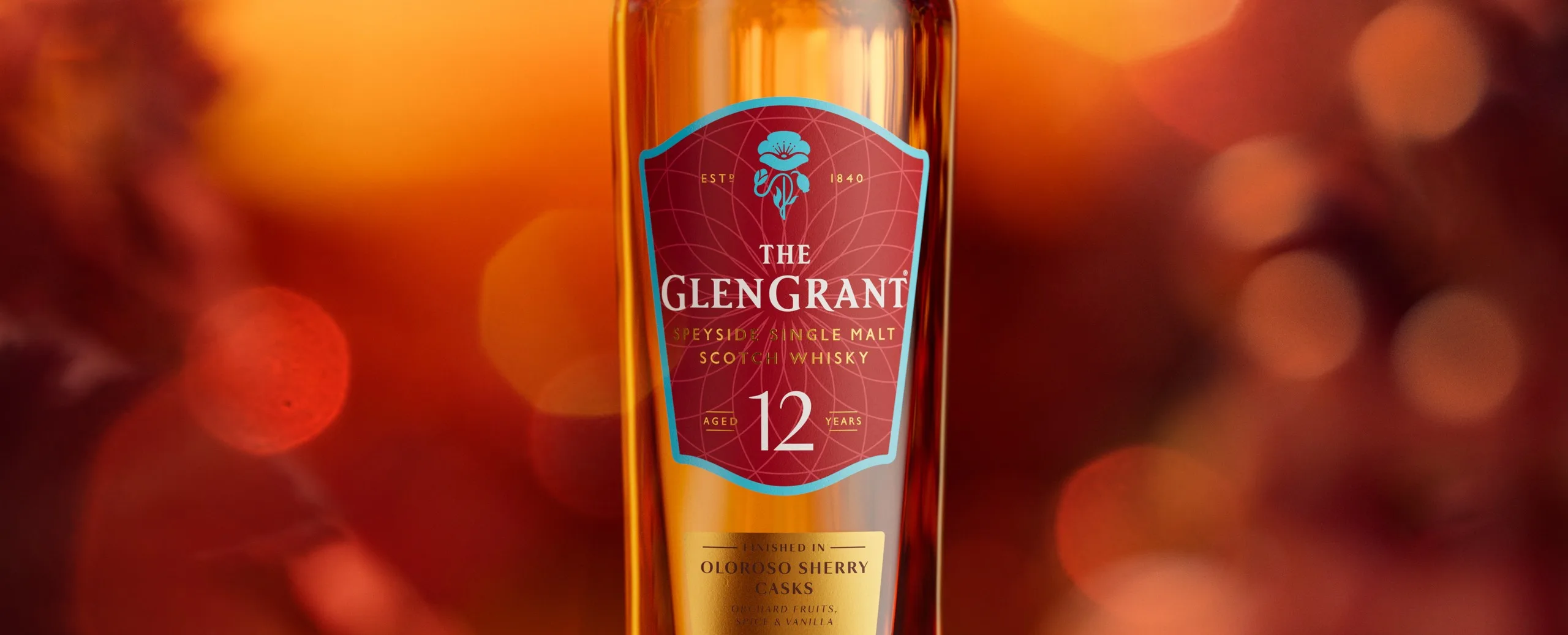 The Glen Grant 12-Year-Old Sherry Finish bottle against a warm orange background