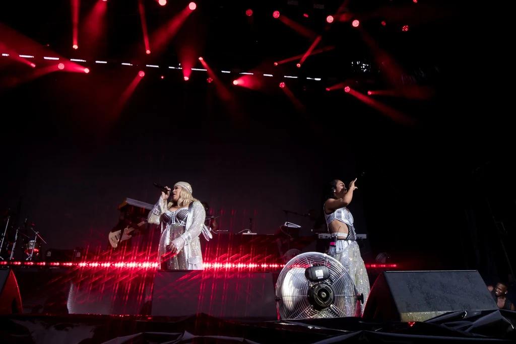 TLC performing on a Singapore Grand Prix concert stage under red spotlights and white LED graphics