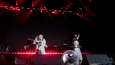 TLC performing on a Singapore Grand Prix concert stage under red spotlights and white LED graphics