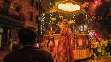 Illuminated Knock-A-Human storefront display with a costumed figure at night