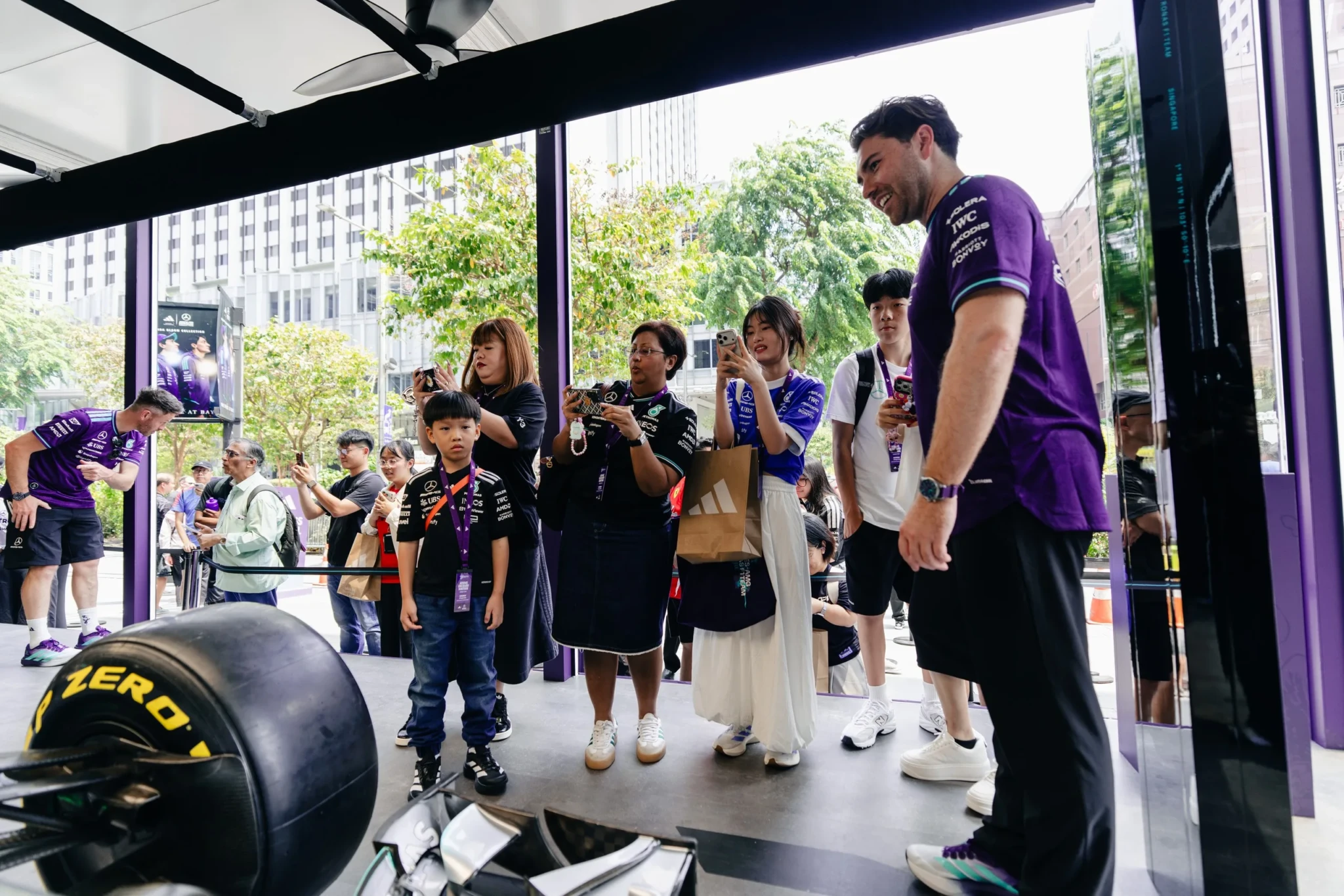 Crowds filming a Mercedes-AMG PETRONAS F1 Team race car at the Orchard Road garage pop-up