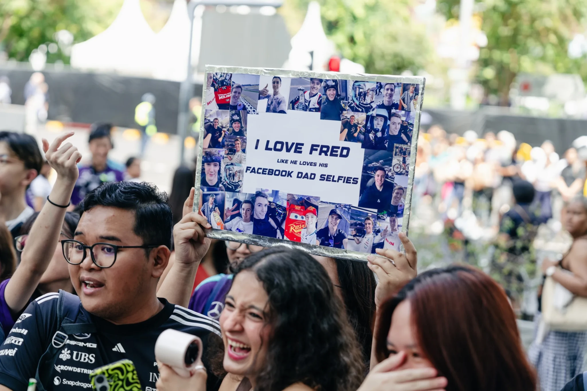 A fan holding a homemade sign supporting Fred Vesti on Orchard Road