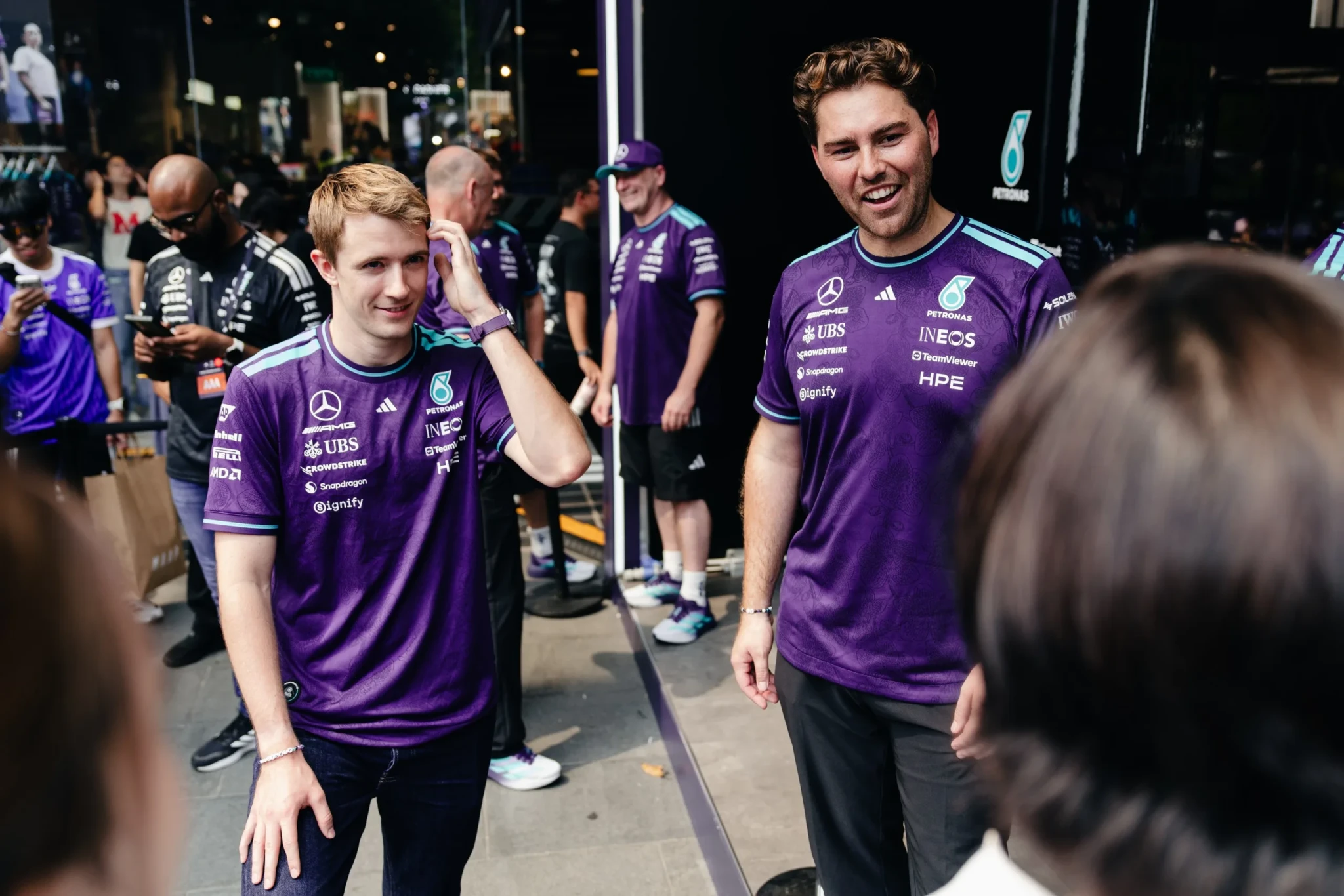 Mercedes-AMG PETRONAS F1 Team members in purple team apparel at the Orchard Road event